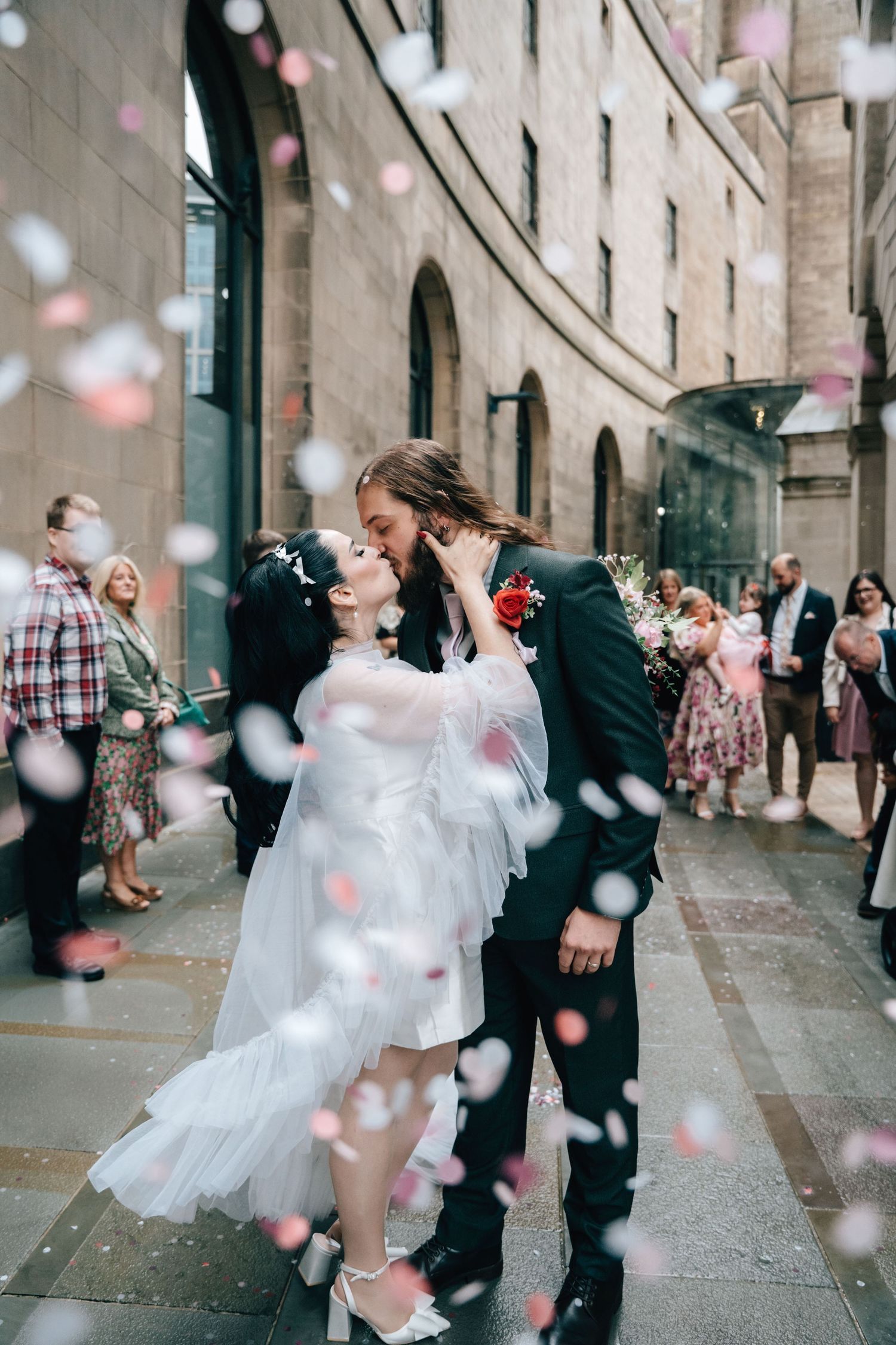 Confetti shot of couple kissing in Manchester city wedding by Manchester wedding photographer Tina Hevingham.