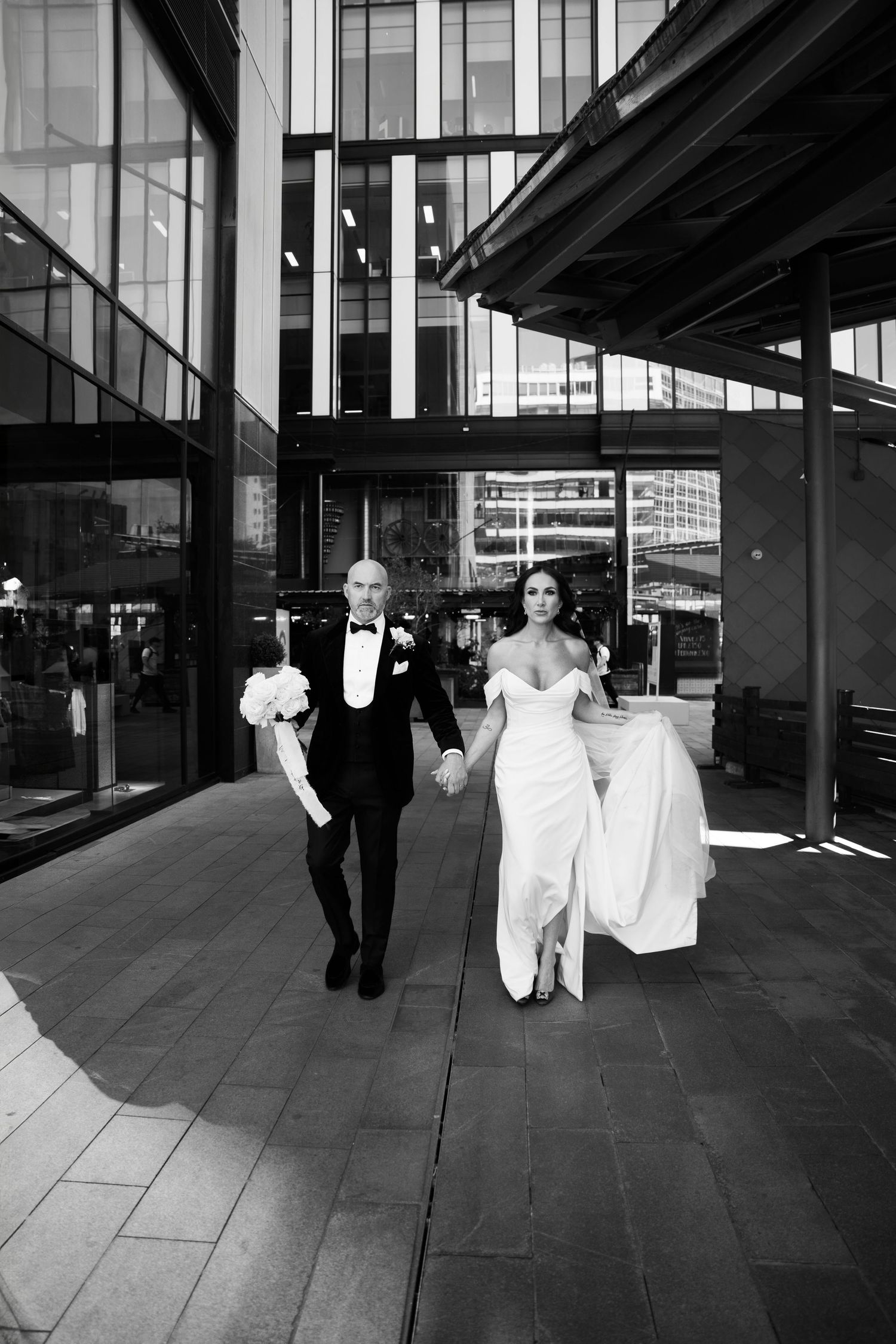 Documenting couple walking hand in an editorial style, in Spinningfields Manchester City Centre by Manchester wedding photographer.