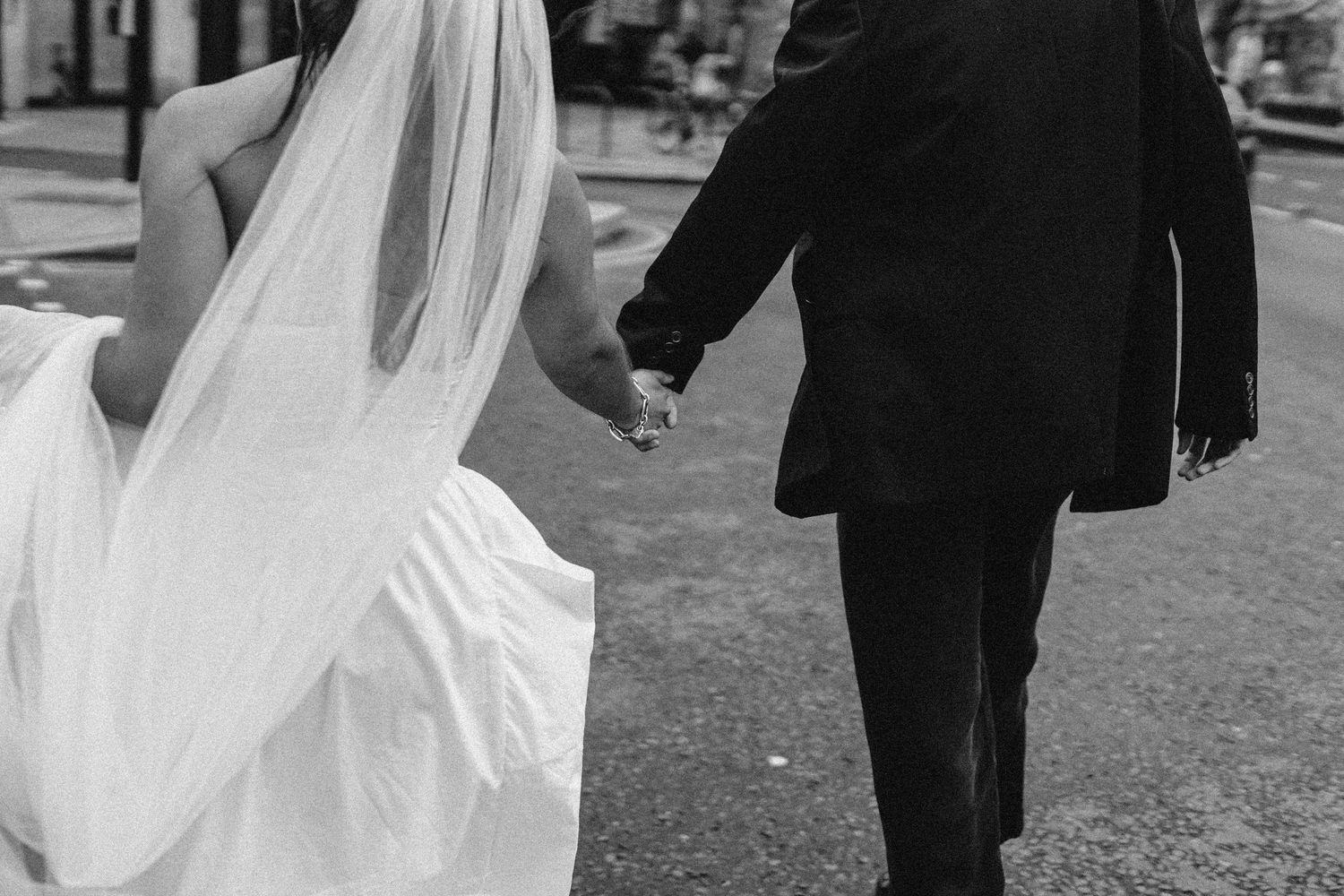 Natural and relaxed bride and groom walking in London city elopement by Manchester wedding photographer Tina Hevingham.