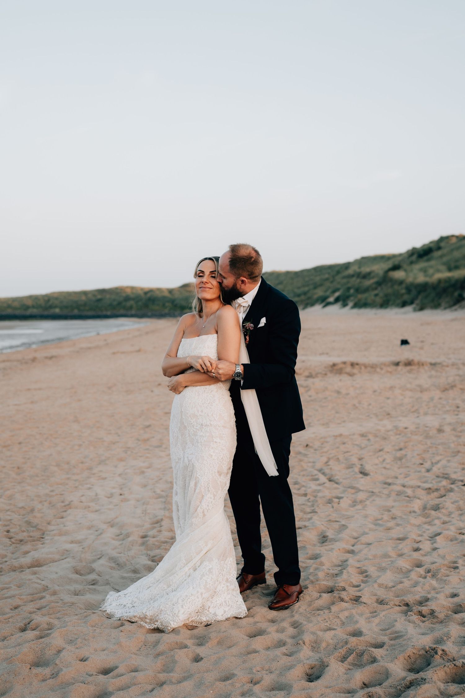 Romantic intimate moment of bride and groom at the beach by Tina Hevingham, Manchester wedding photographer.