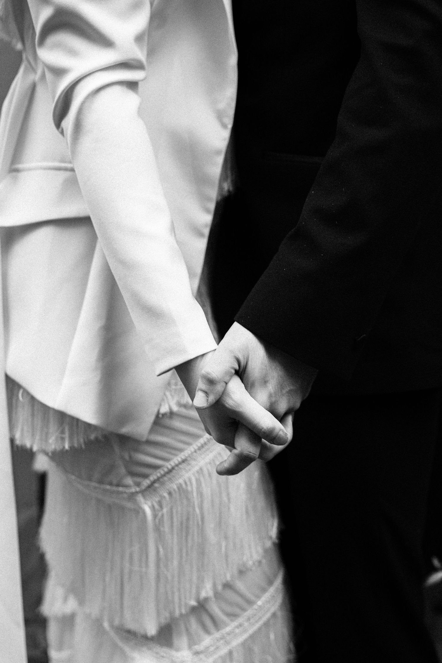 Natural documentary photograph of couple holding hands by Manchester wedding photographer.