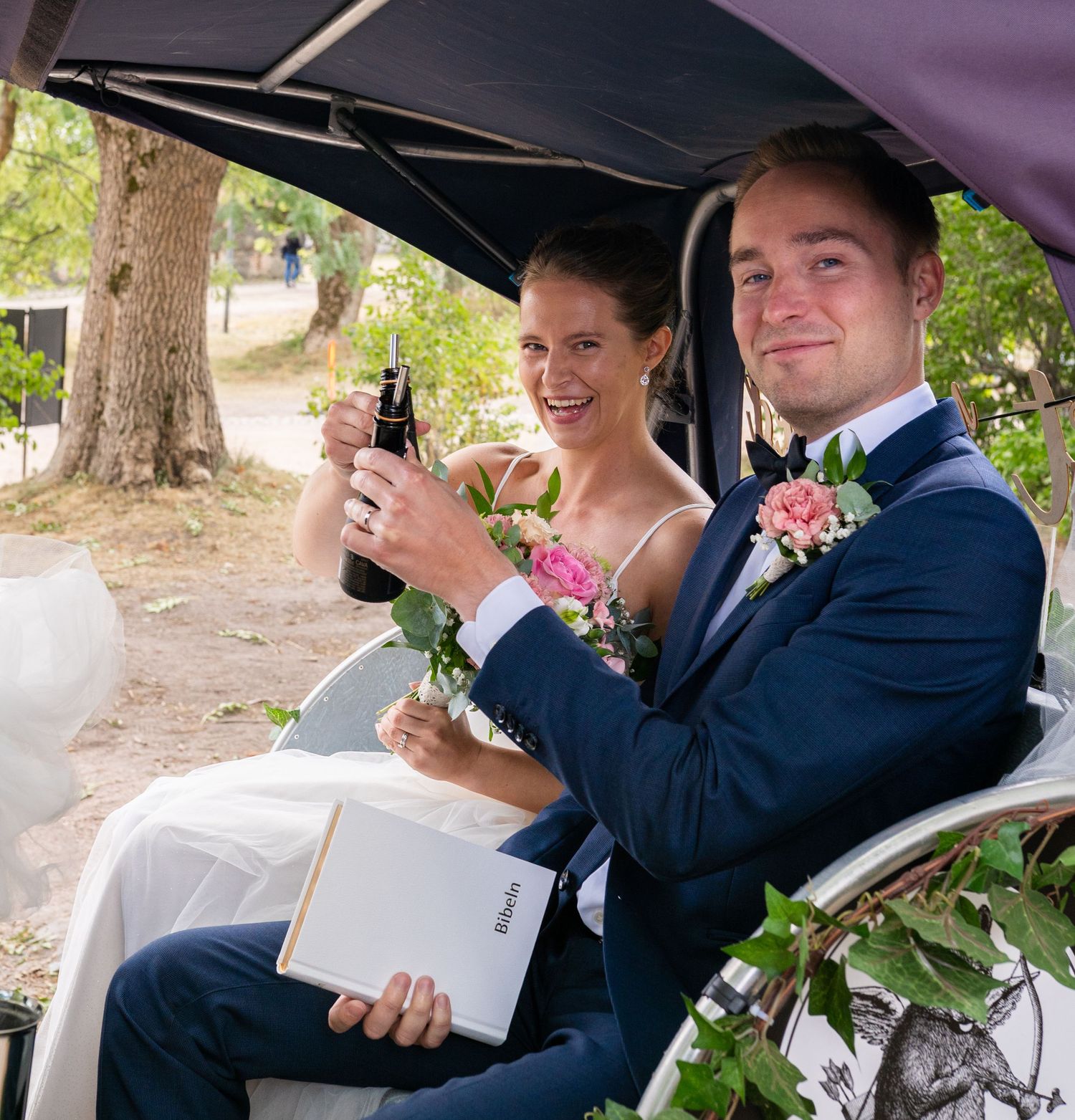 Bride and groom toast with champagne in a decorated wedding rickshaw.