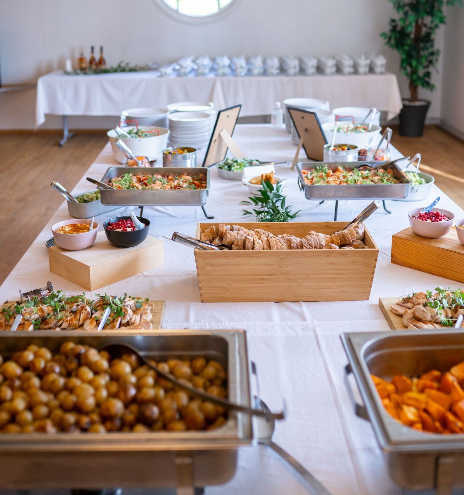 Abundant wedding buffet spread featuring salads, roasted potatoes, bread, and colorful side dishes.