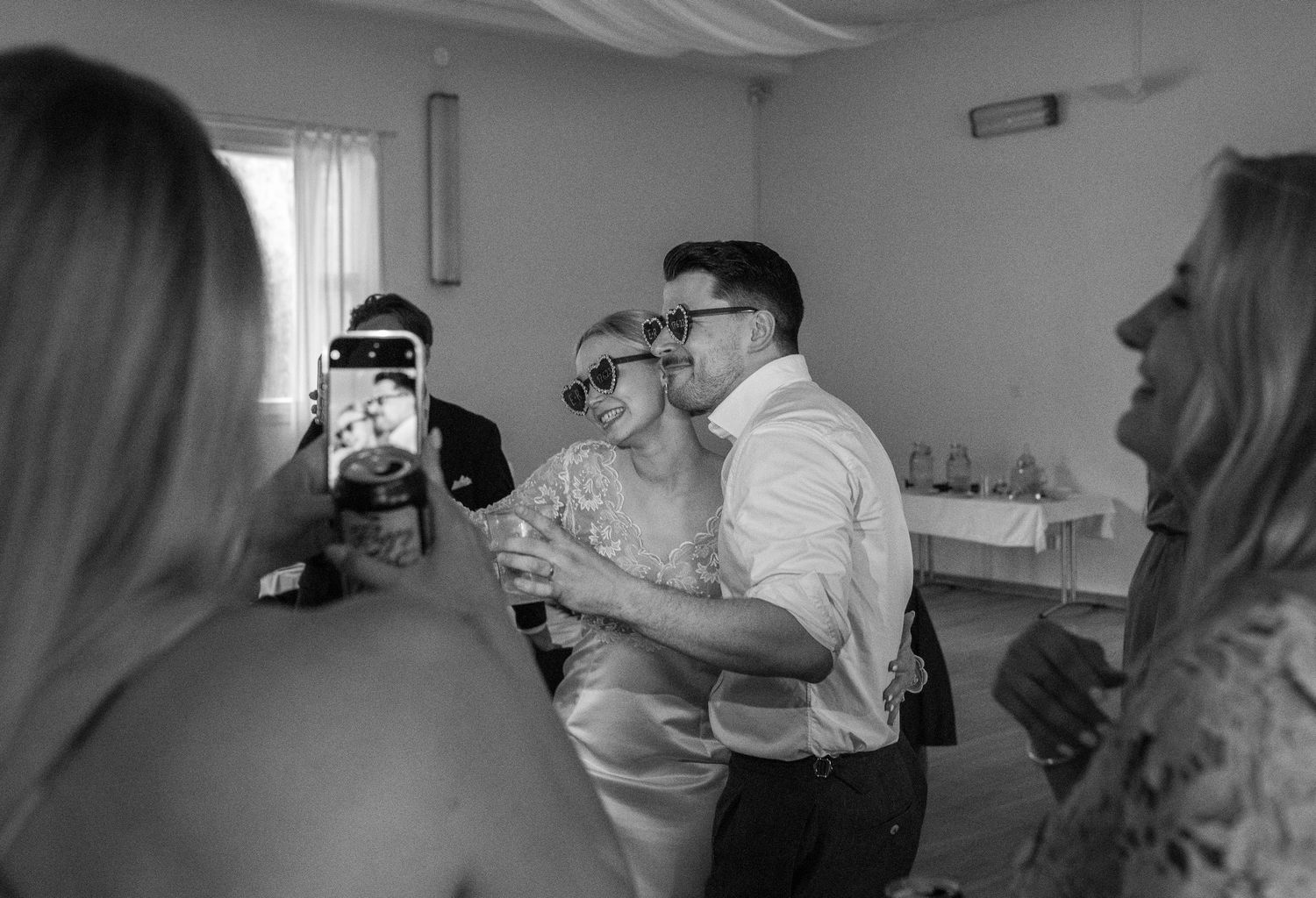 Couple poses for a fun black and white photo together at their wedding reception celebration.