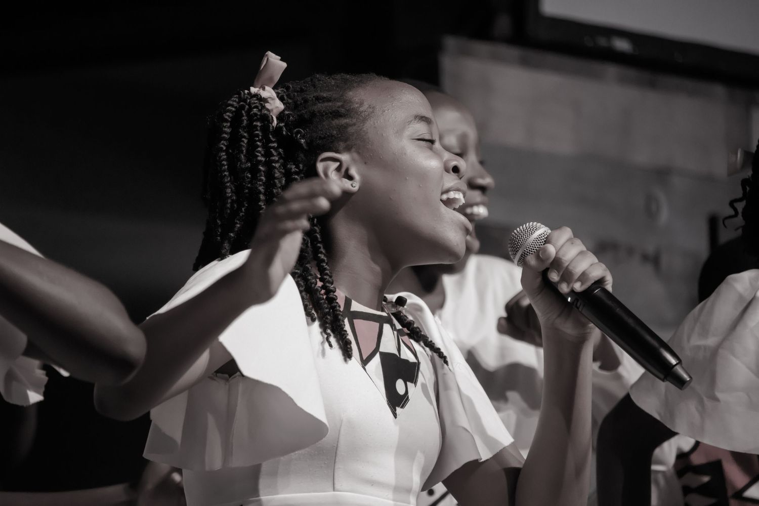 Black and white performance photos of singers on stage during a concert.