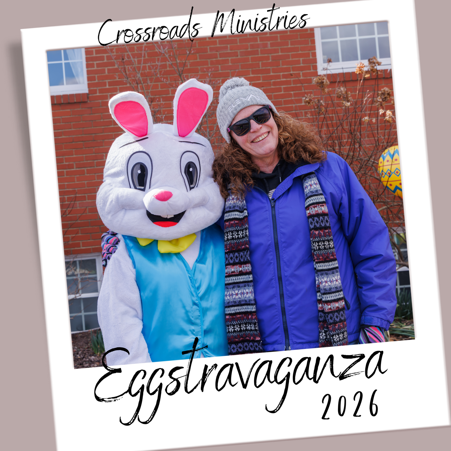 A person in a blue jacket poses with the Easter Bunny mascot wearing a light blue vest at Eggstravaganza 2024.