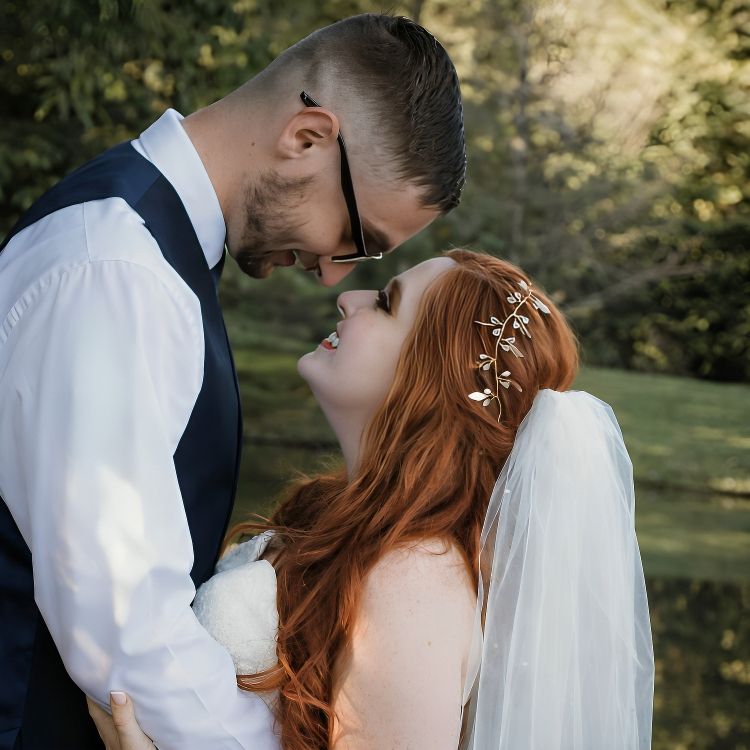 Intimate wedding moment captured with bride and groom in natural outdoor setting.