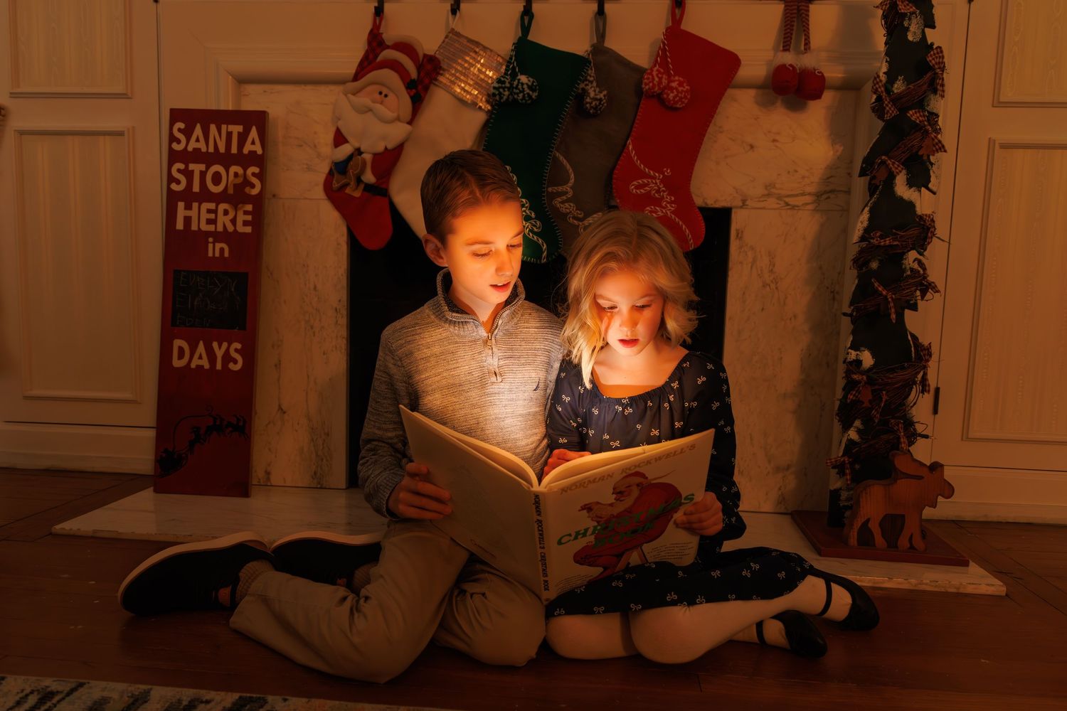 Holiday decorations including stockings and Santa signs adorn a warmly lit room.