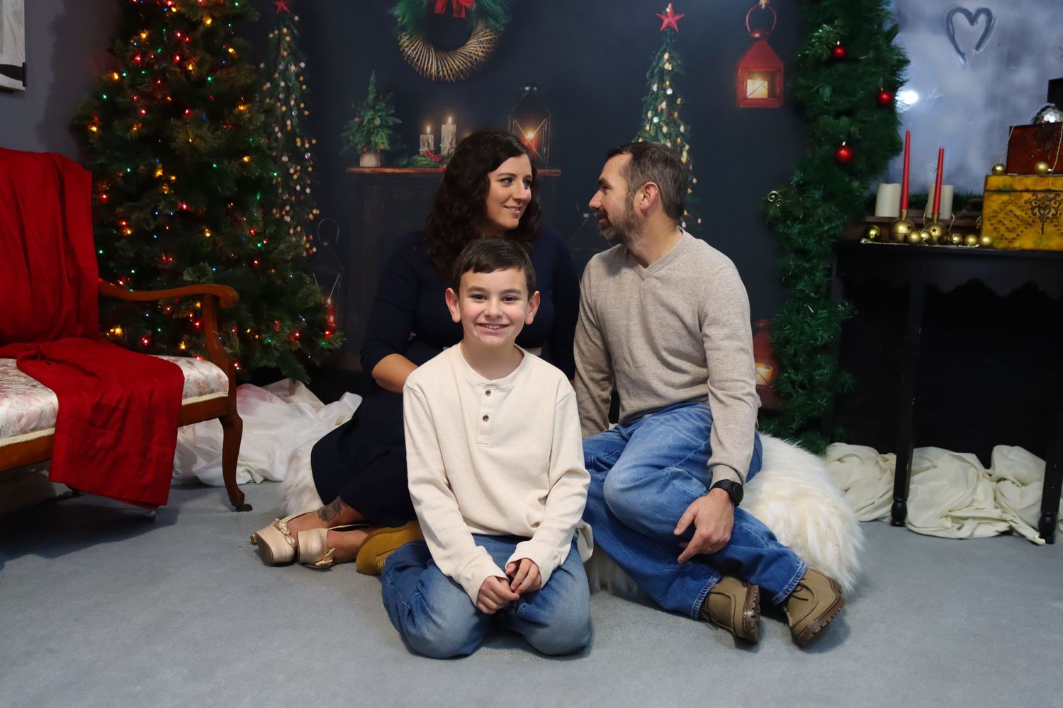 Family holiday portrait session with Christmas tree and festive decorations in background.