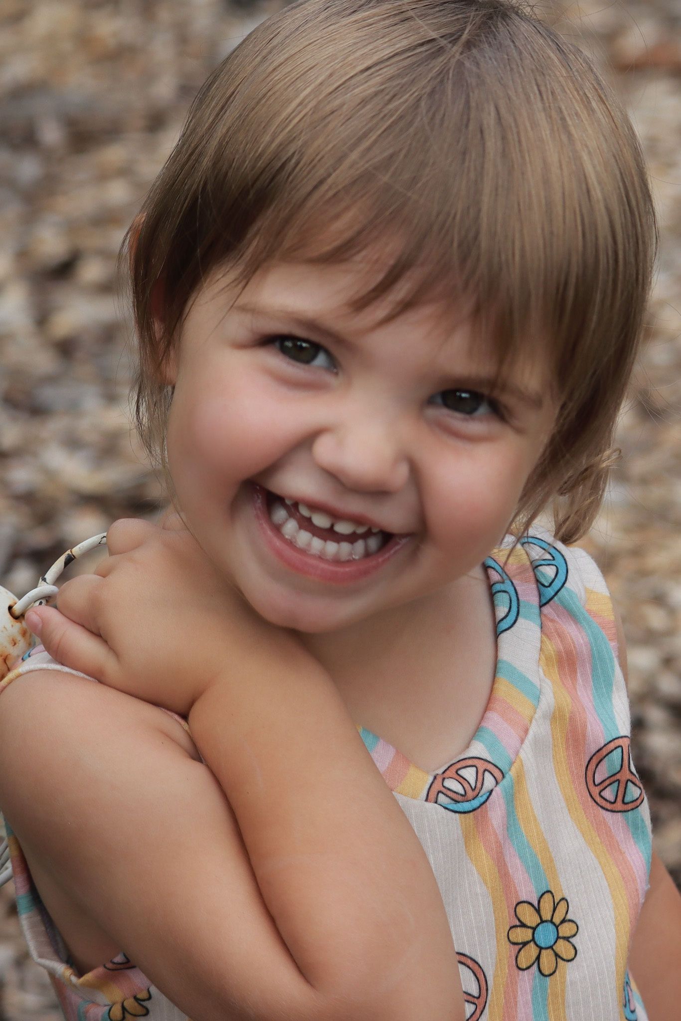 Close-up portrait of child wearing peace sign dress against natural background.