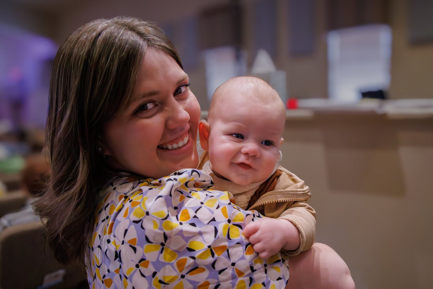 A joyful moment between parent and baby in an indoor setting.