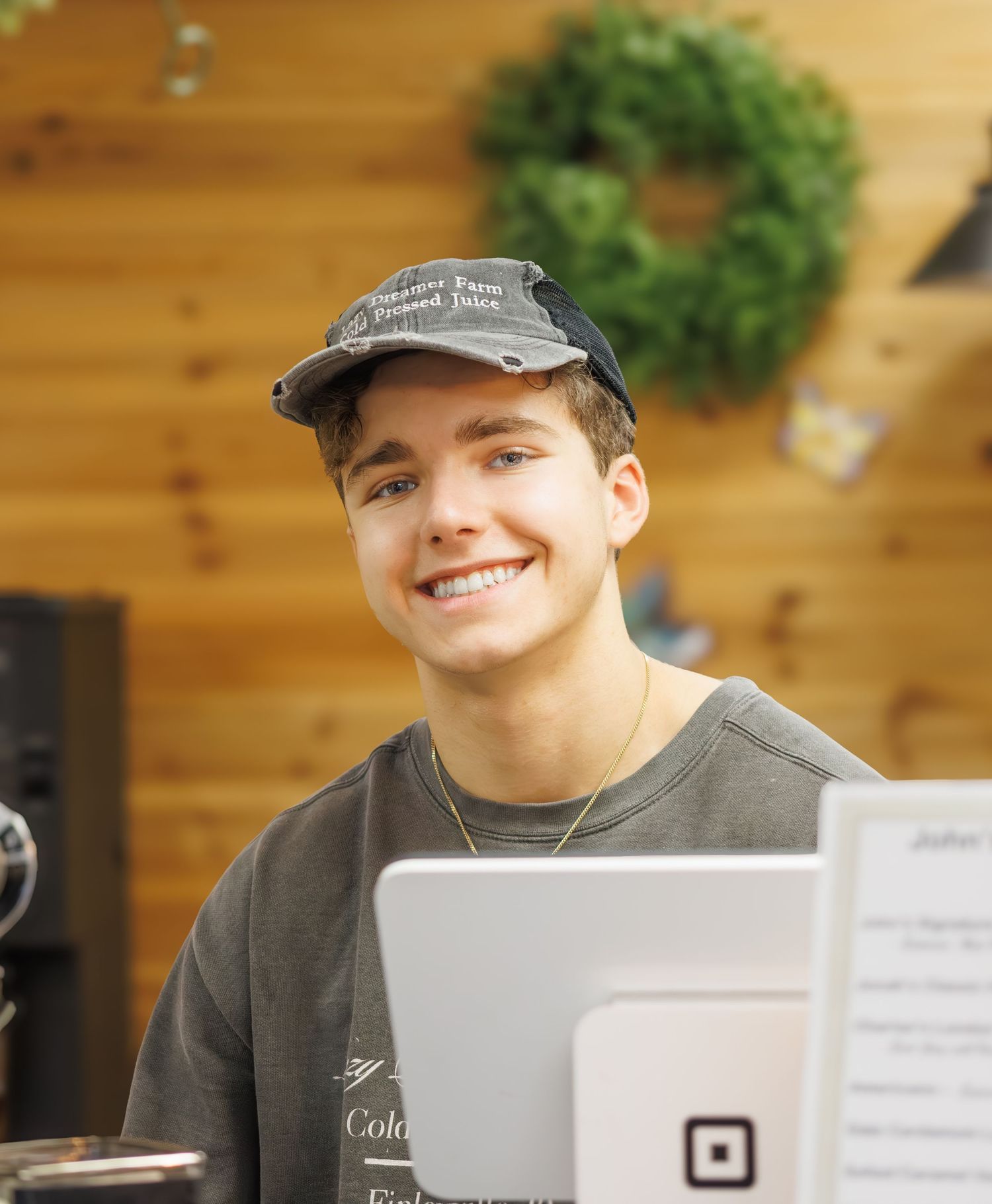 Person working at desk with computer and papers in wooden-paneled office setting.