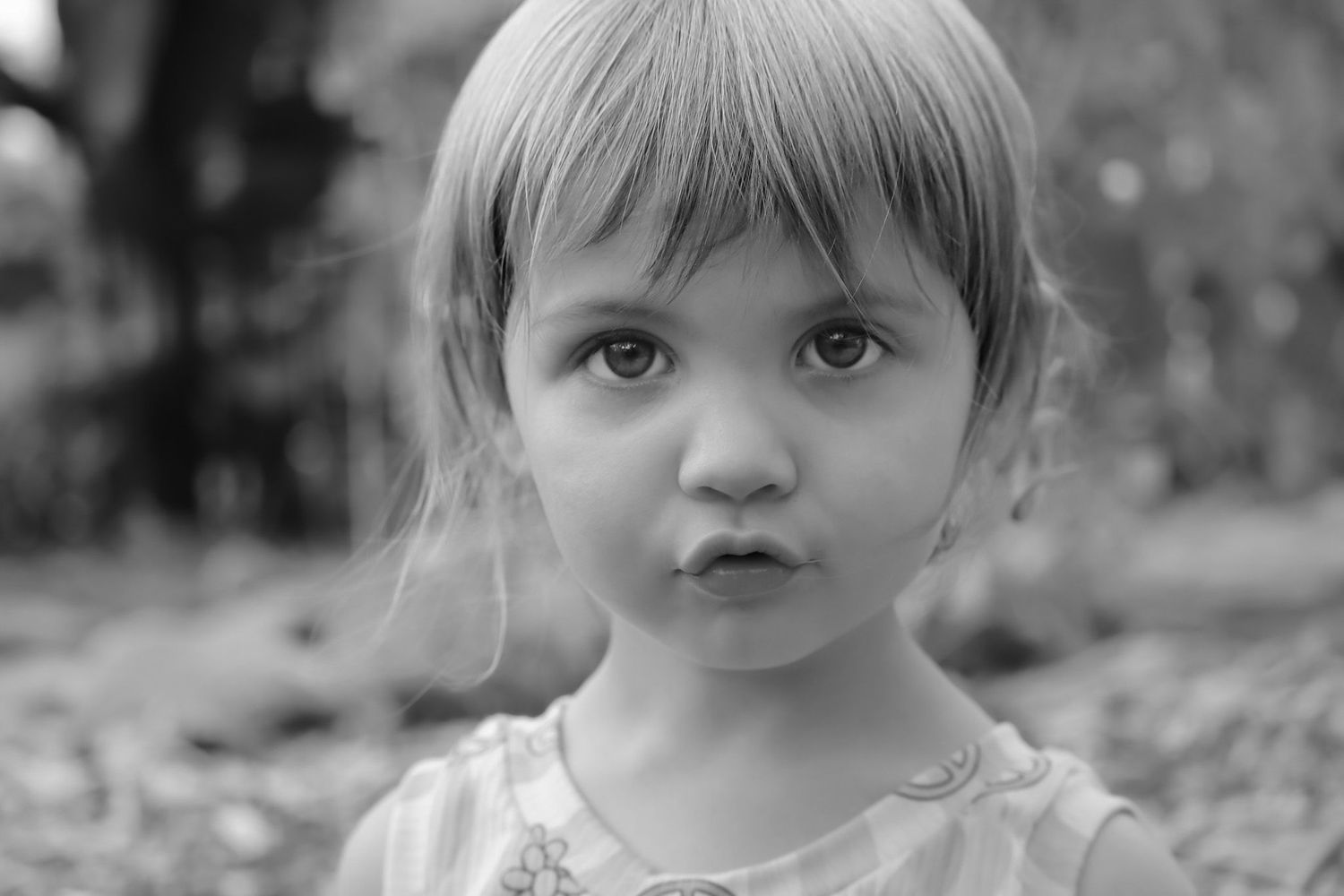 Black and white close-up portrait of a child with bangs.