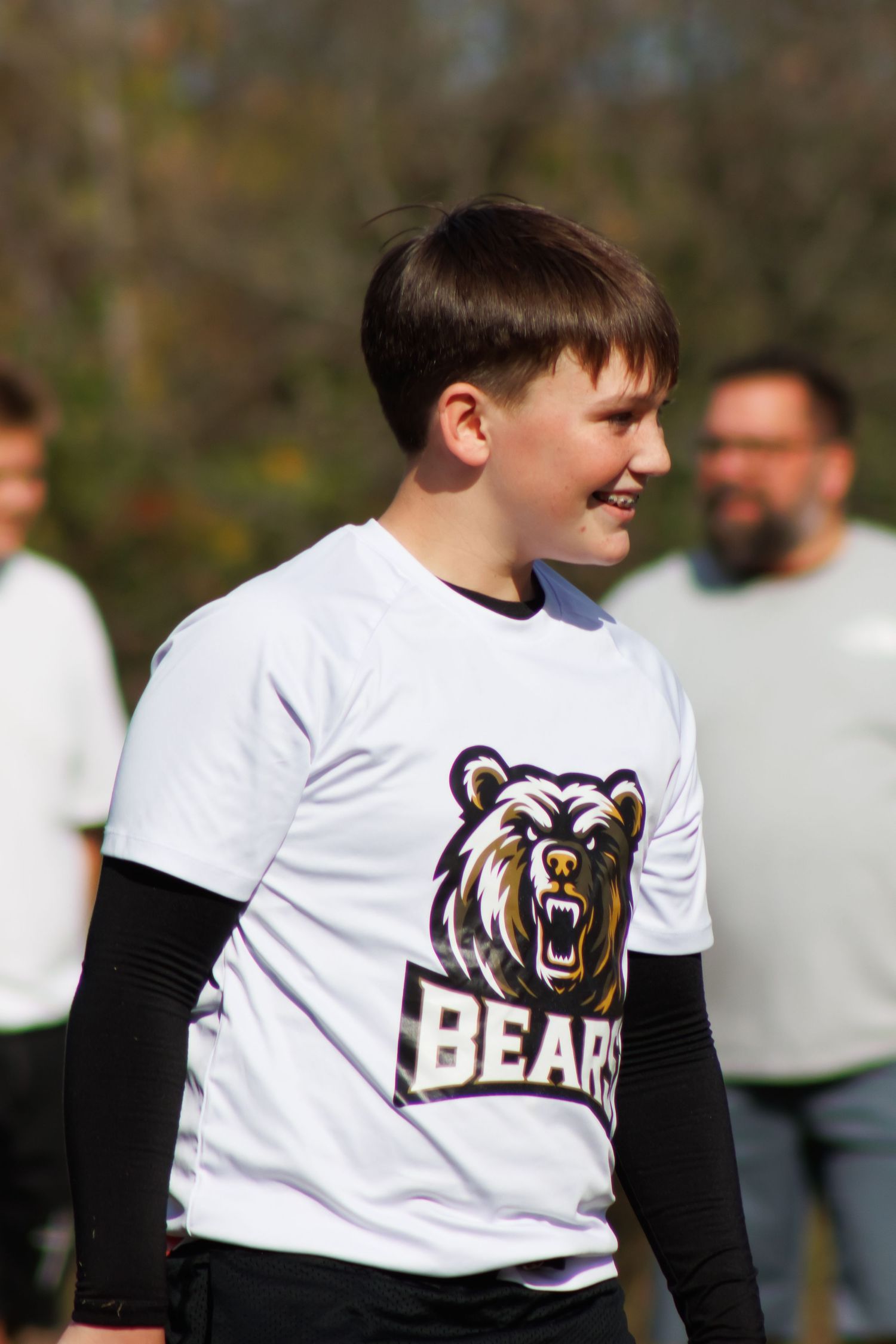 Youth sports team wearing white jerseys with Bears logo and black long sleeves.
