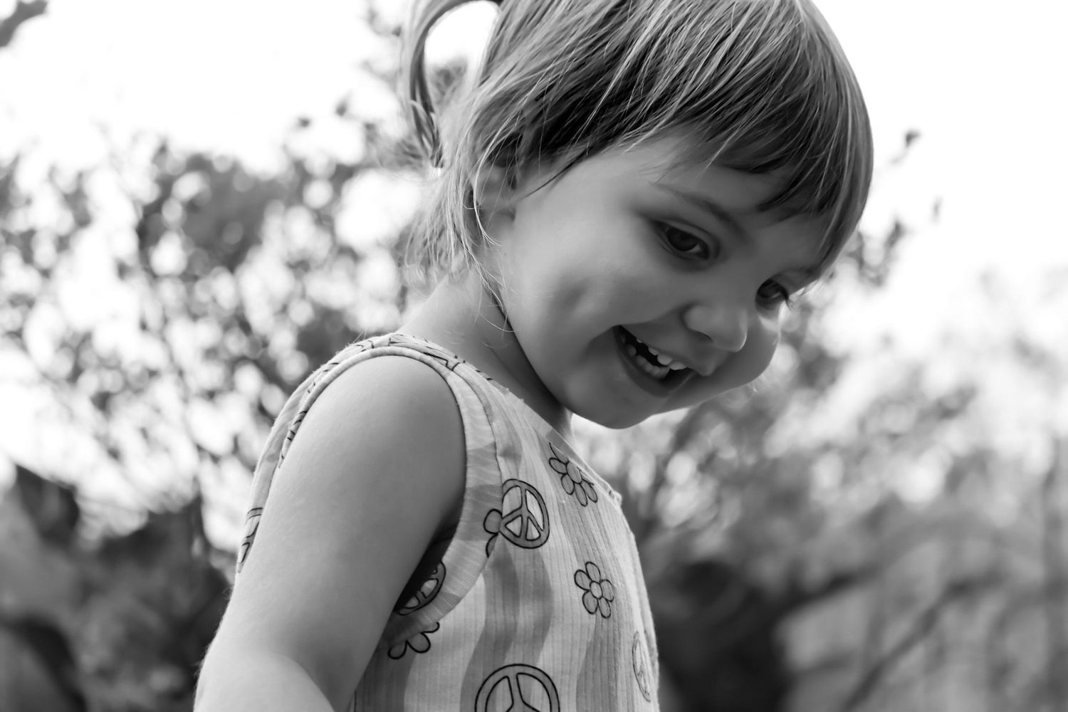 A black and white candid photo capturing laughter and joy in an outdoor setting.