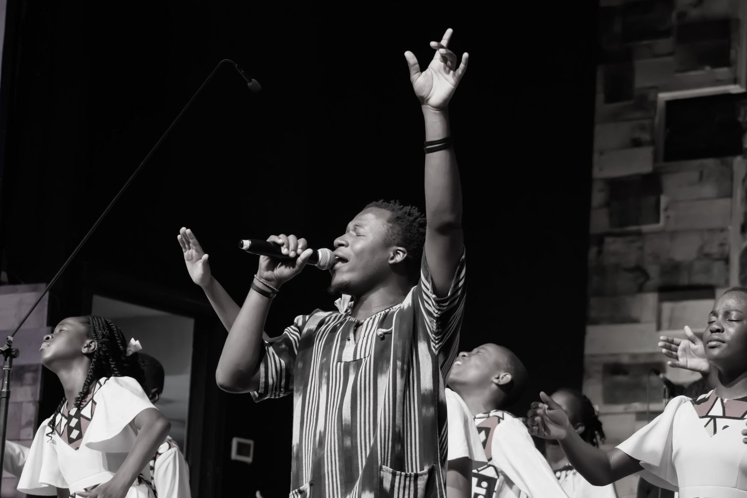 Performers singing with raised hands during an emotional gospel performance.