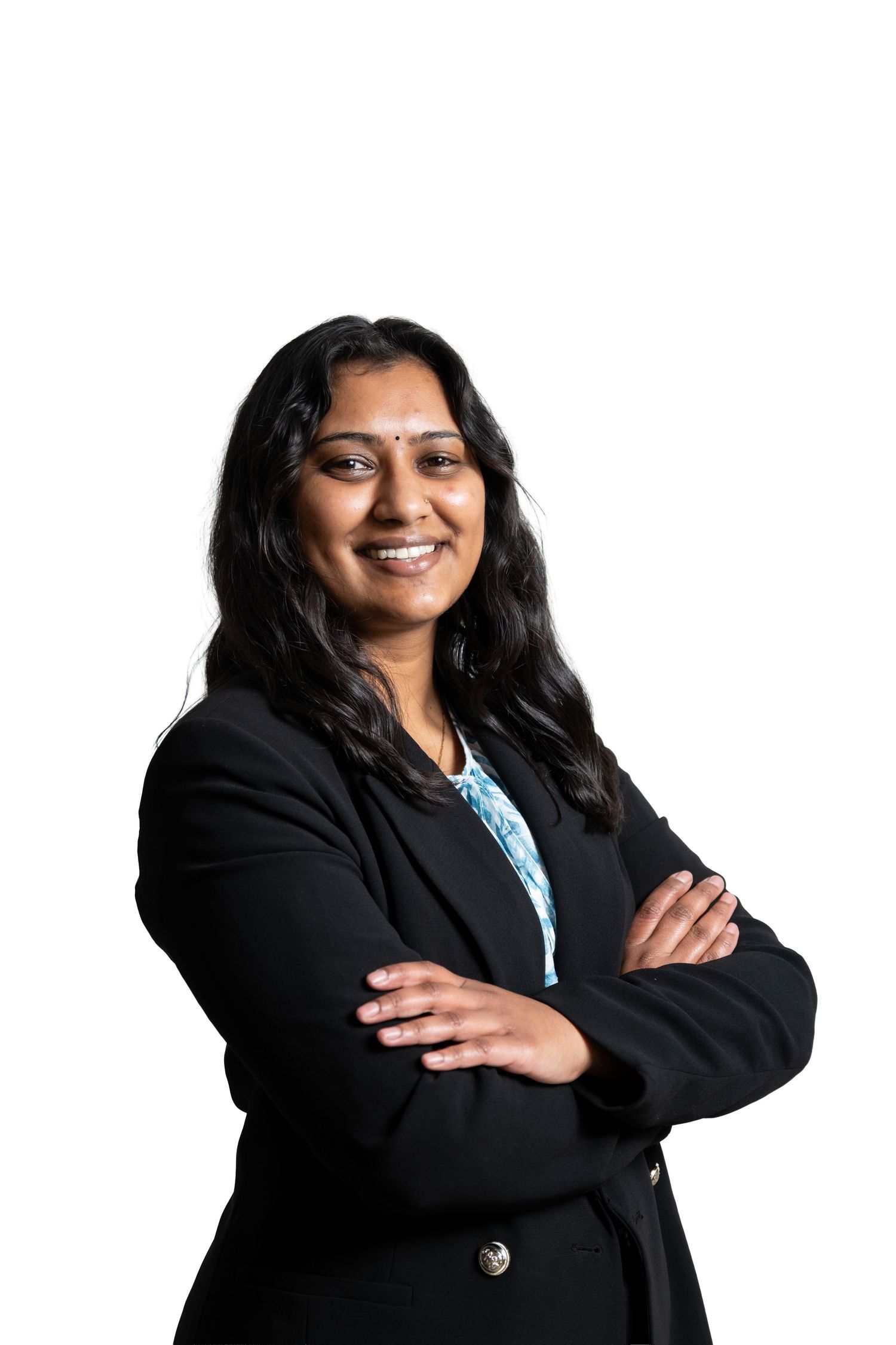Professional in business attire posing with crossed arms against white background.