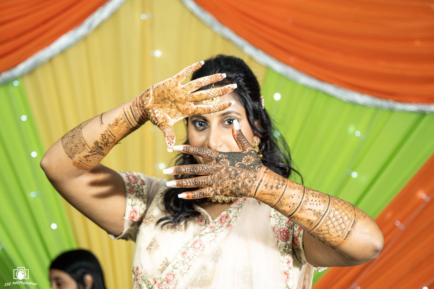 Traditional Indian bridal poses showing intricate henna designs on hands.