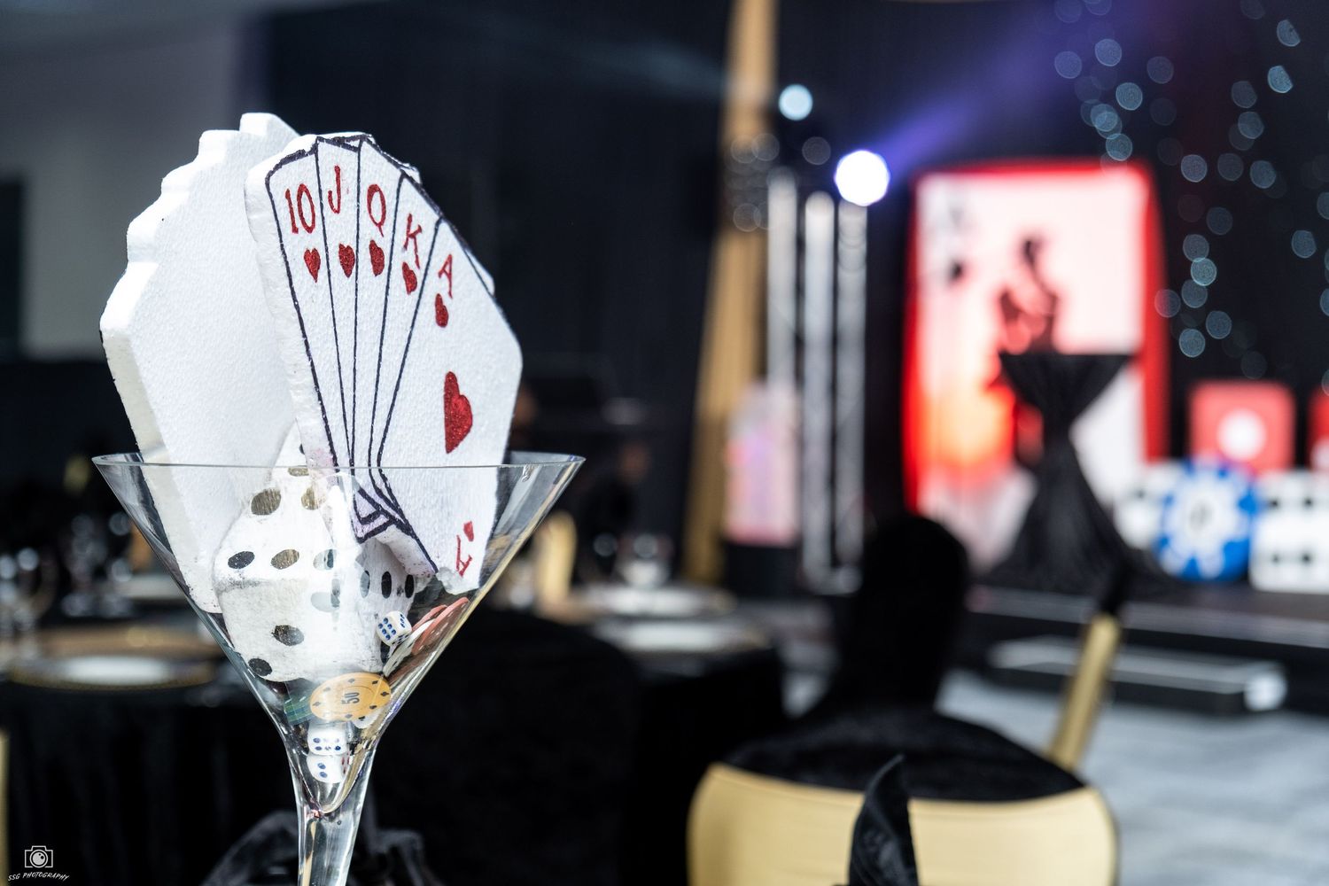 Casino-themed table decorations featuring playing cards displayed in martini glasses.