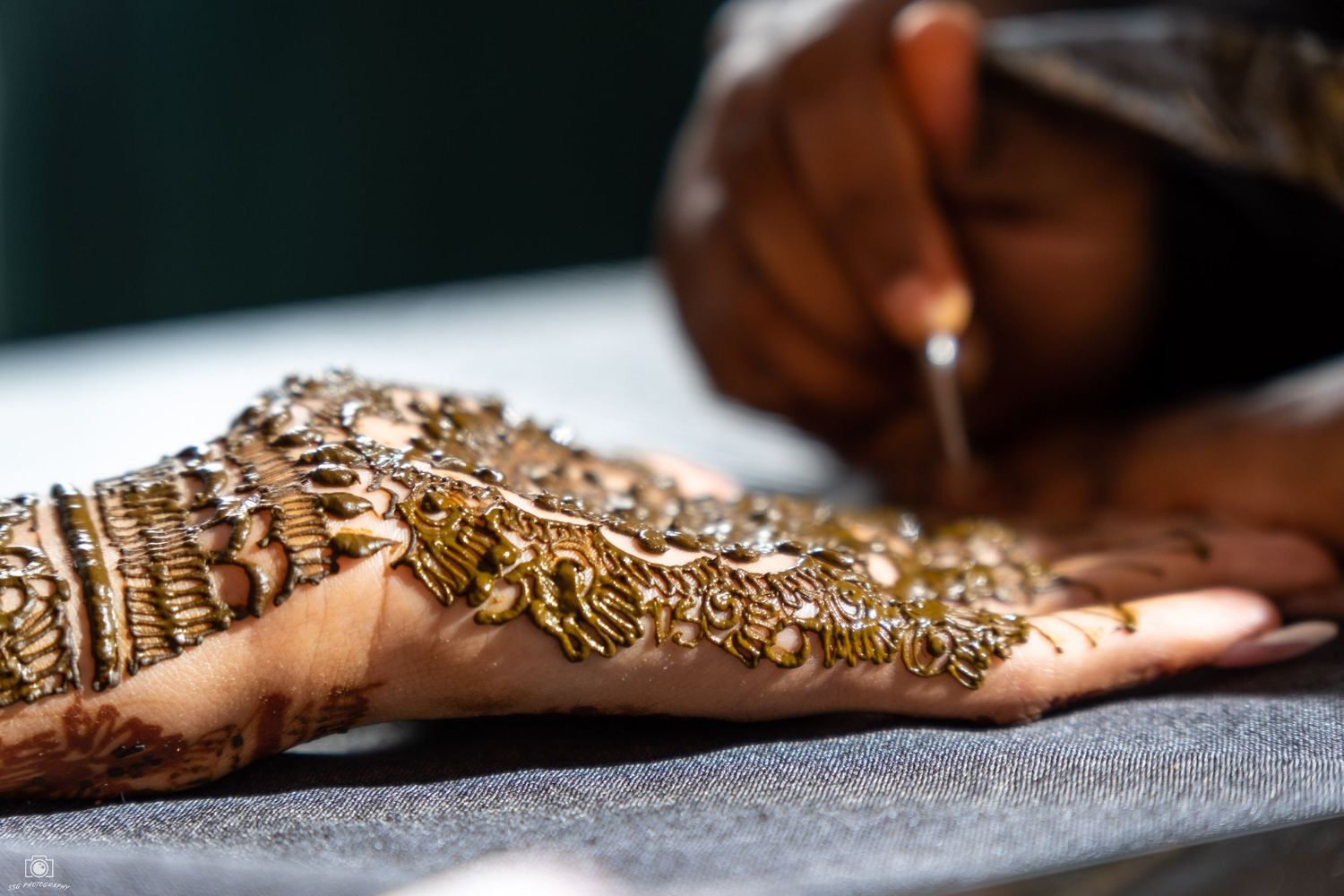 Detailed shot of intricate golden jewelry and henna designs.