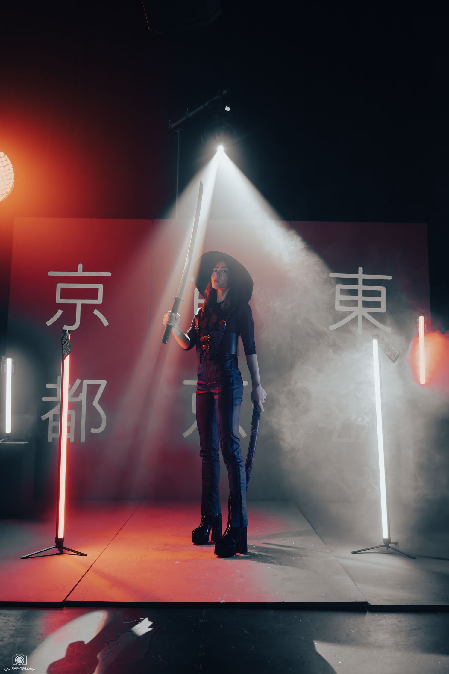 Artistic photo with dramatic lighting and Japanese characters on wall in dark studio setting.