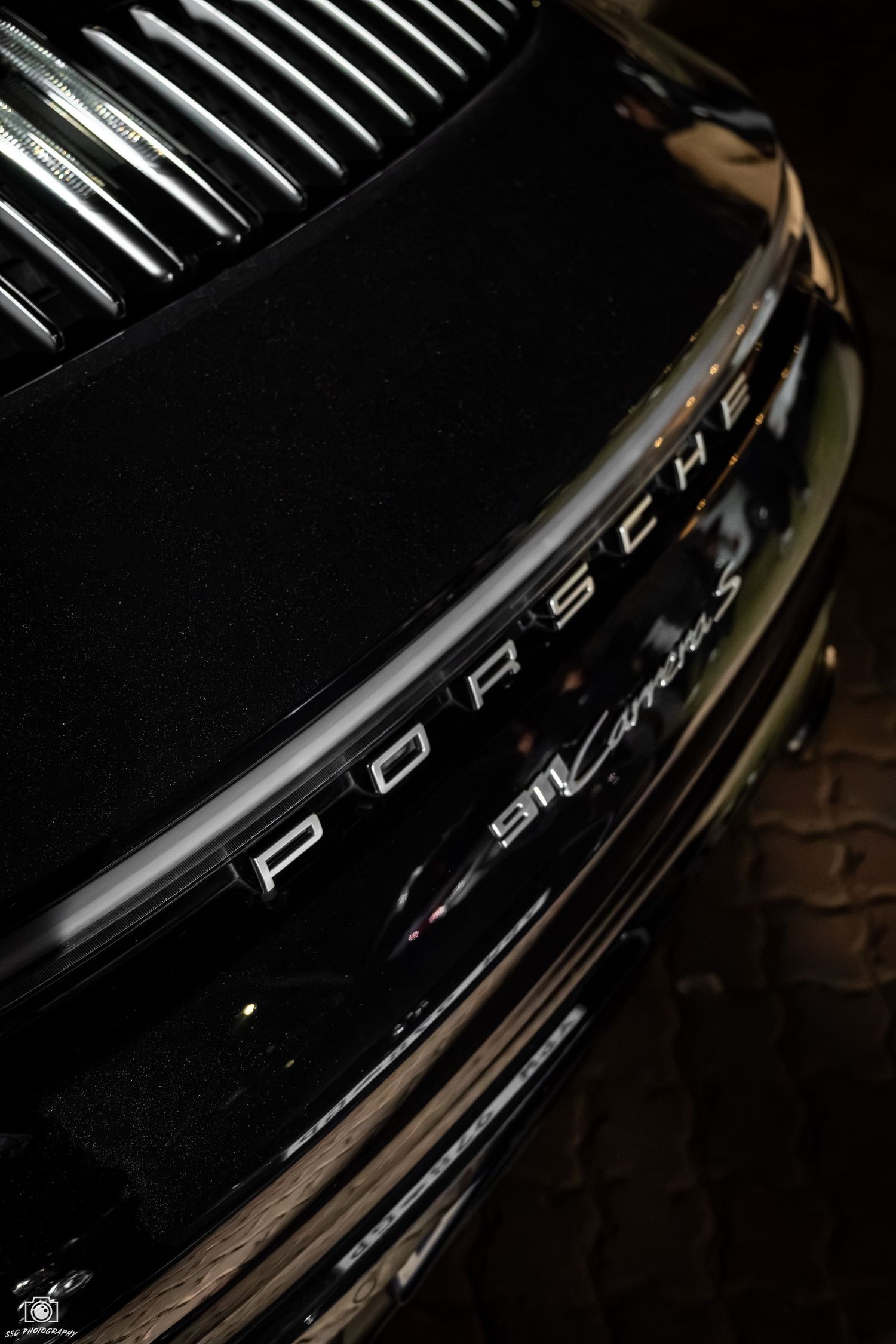 Close-up detail shots of a black Porsche vehicle showing sleek design elements.