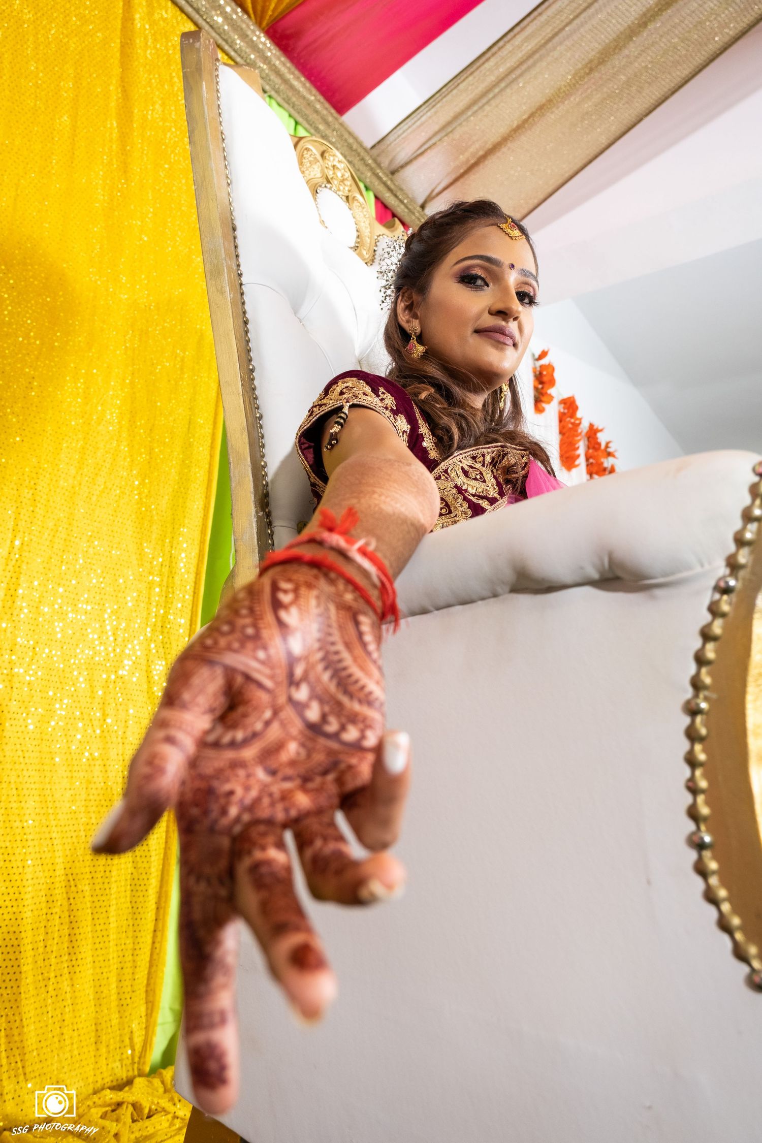 Artistic angles of bridal preparation with yellow and pink drapery in the background.