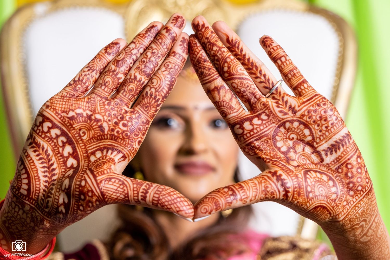Close-up shots of hands decorated with intricate henna designs for an Indian wedding ceremony.