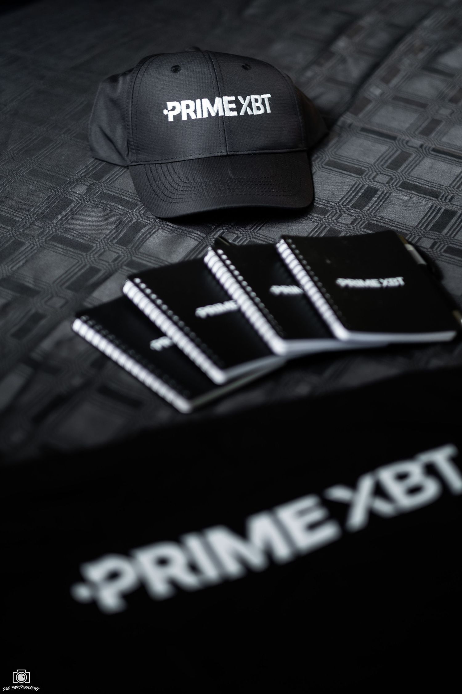 Black baseball caps with white PRIME XBT branding displayed in a stylish product photography sequence.