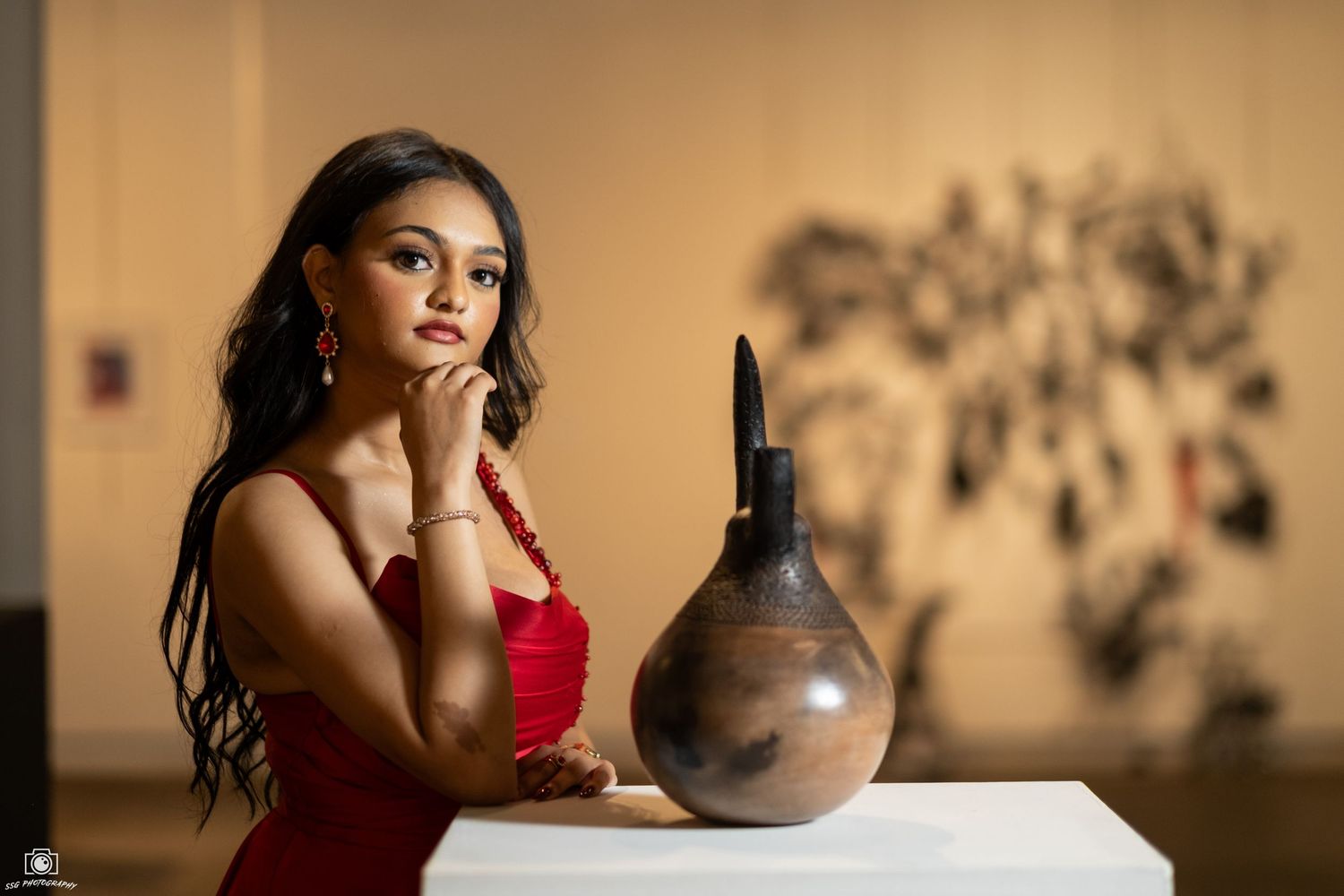Artistic portrait with a clay vase in warm sepia tones against a neutral background.