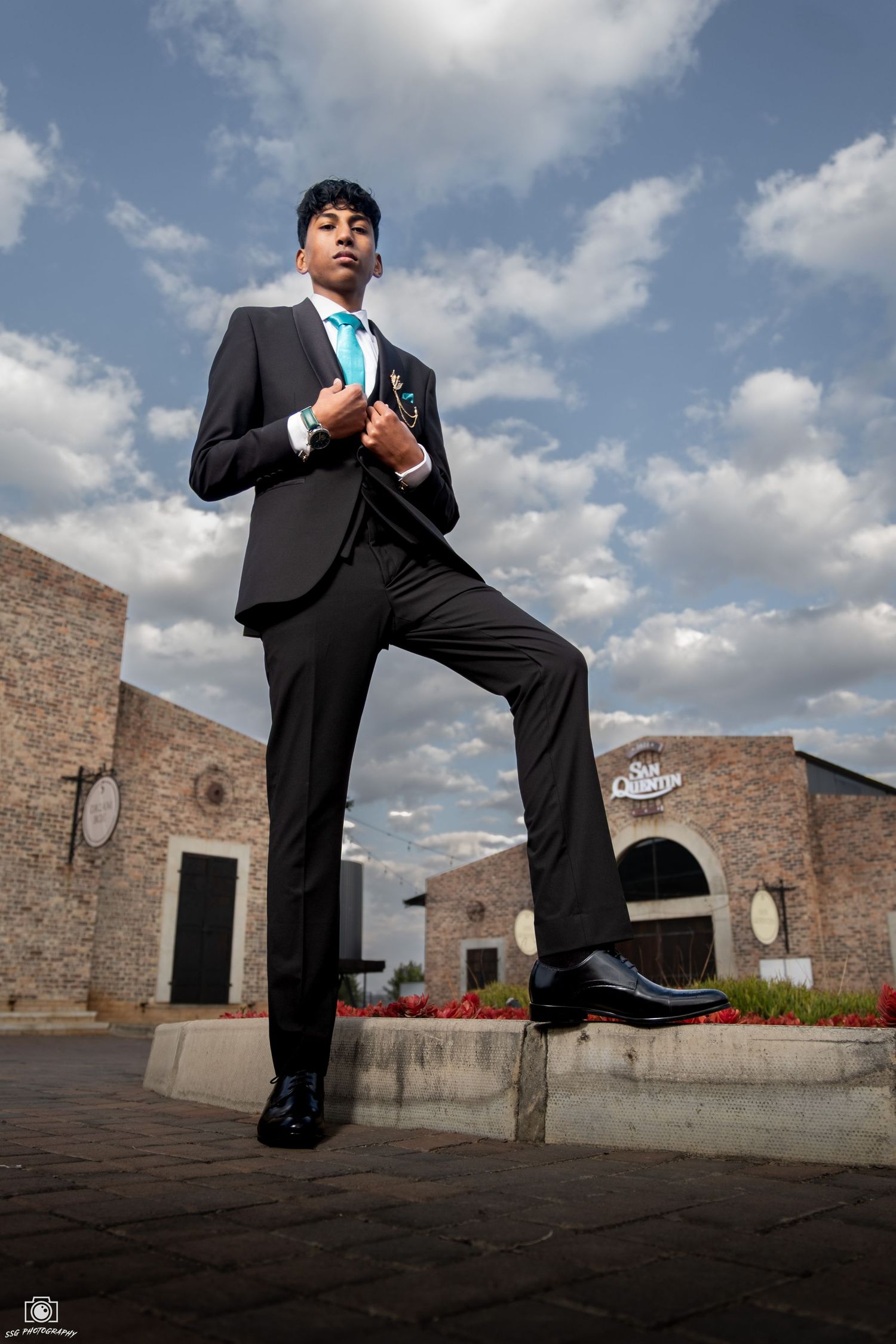 Creative sequence of person in suit striking dynamic poses against brick architecture.