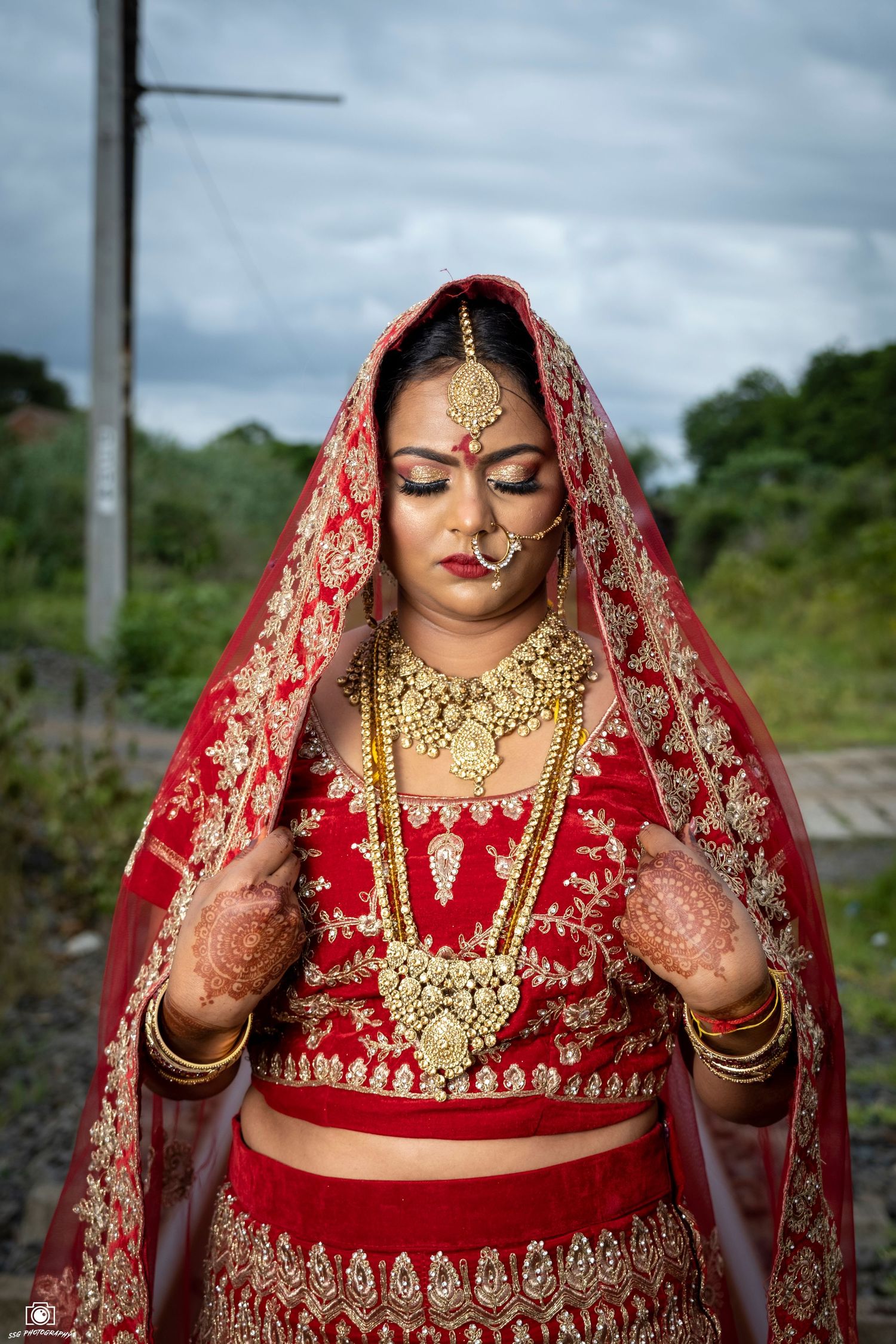 Close-up details of traditional Indian bridal attire with intricate gold embellishments and henna.