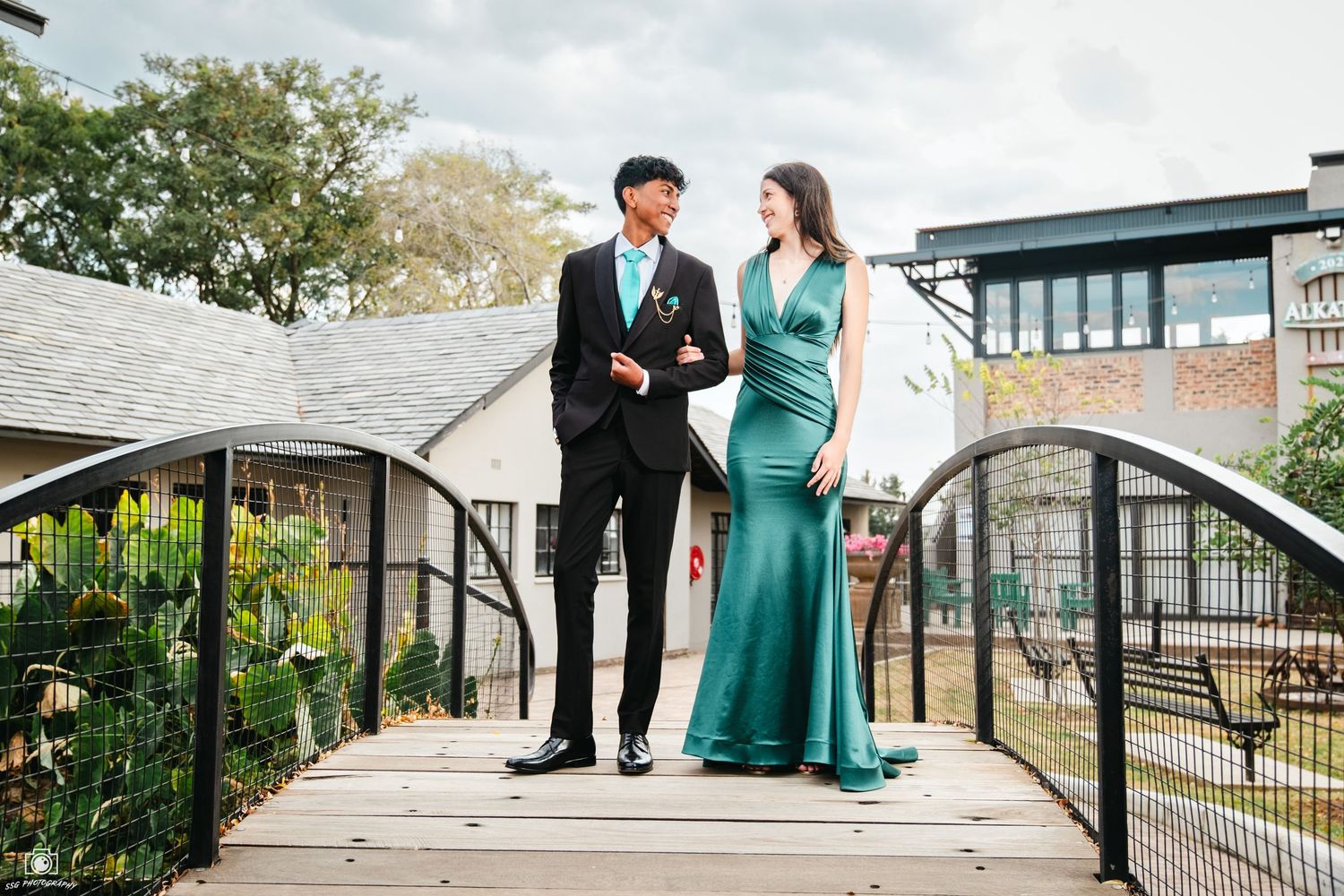 Outdoor portrait session with people in formal attire on a modern architectural walkway.