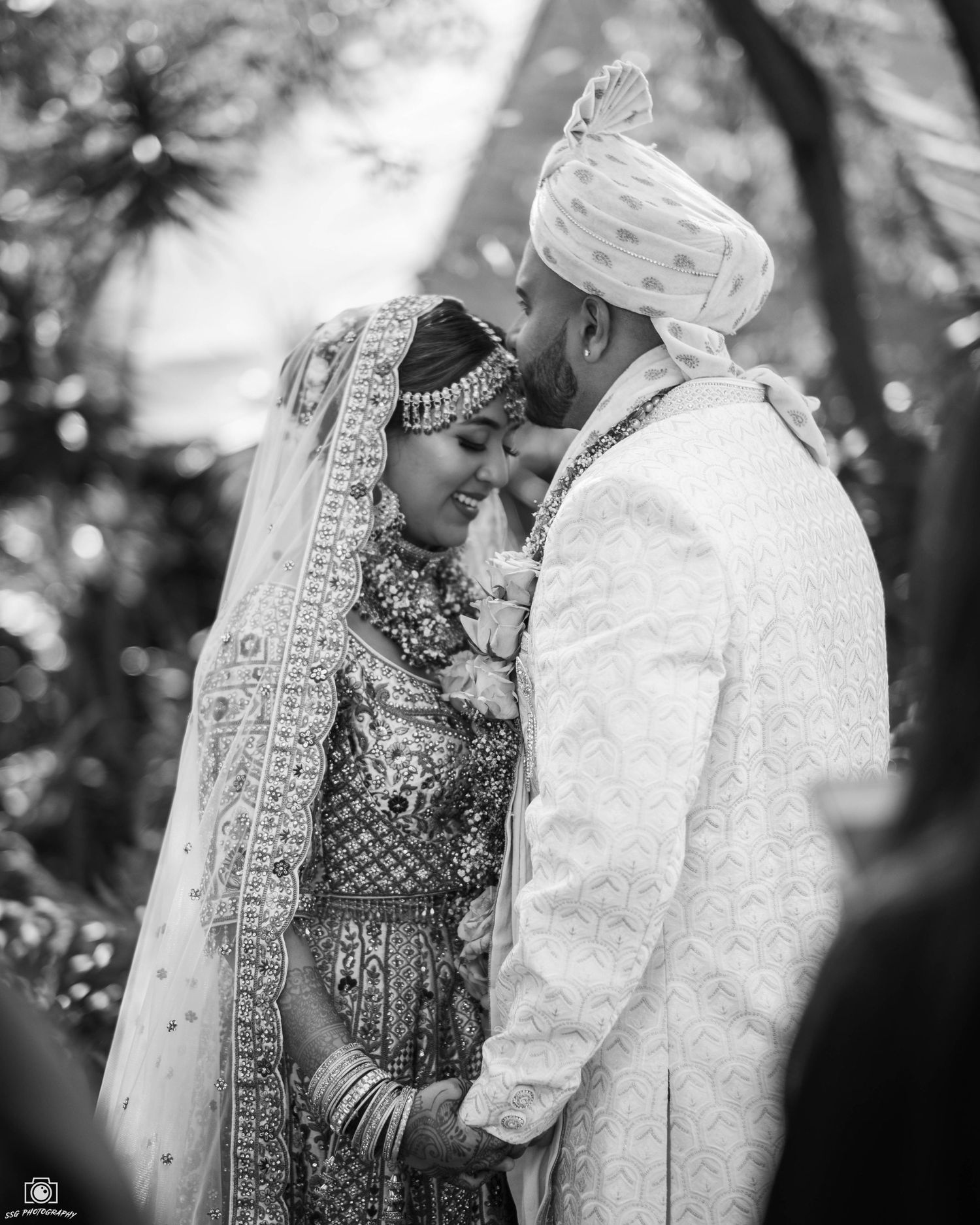Black and white wedding portrait showing intimate moment between couple.