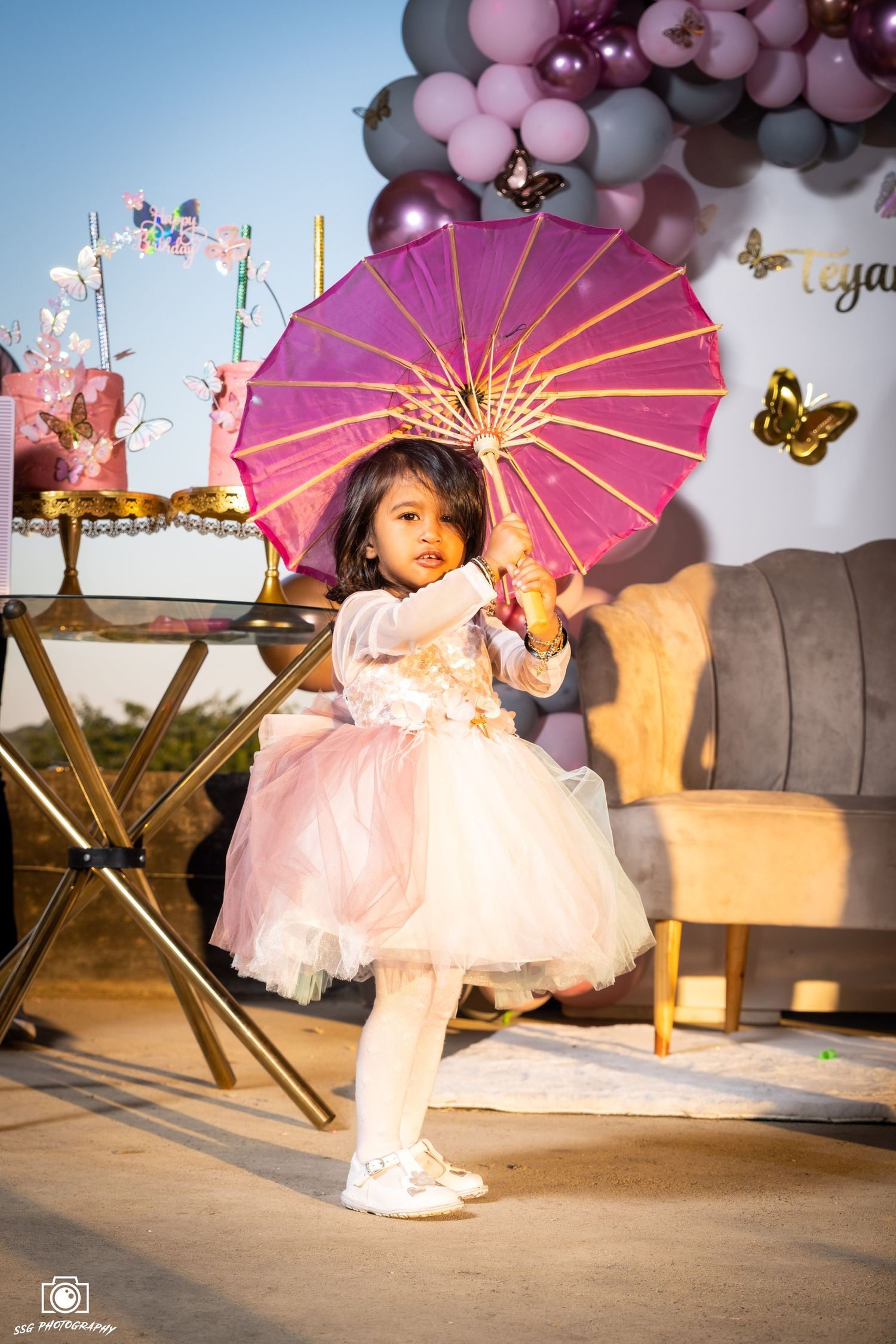 Capturing candid moments at a Gauteng wedding: A child in a pink and white dress with a lit-up umbrella, photographed by SSG Photography.