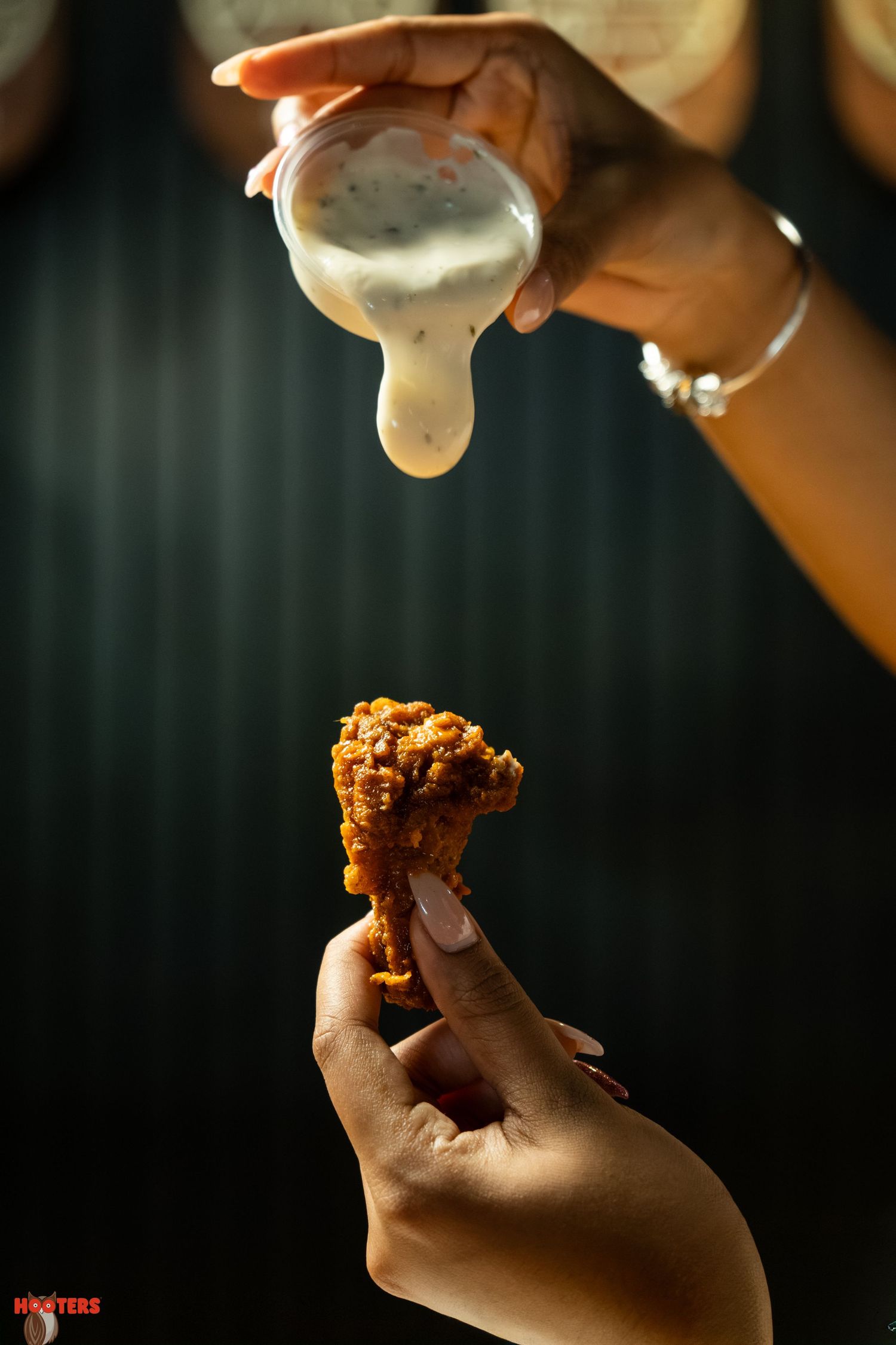 Close-up sequence of hands dipping and eating fried food with sauce.