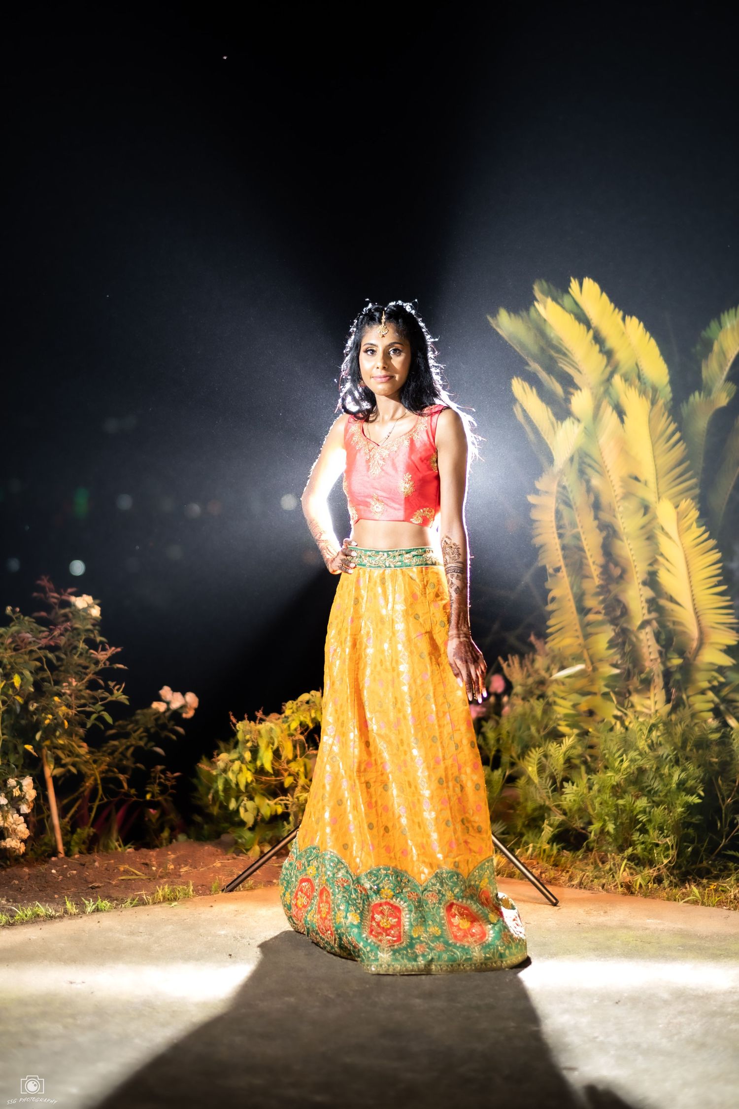 Fashion portrait in bright yellow and orange traditional dress with dramatic lighting.