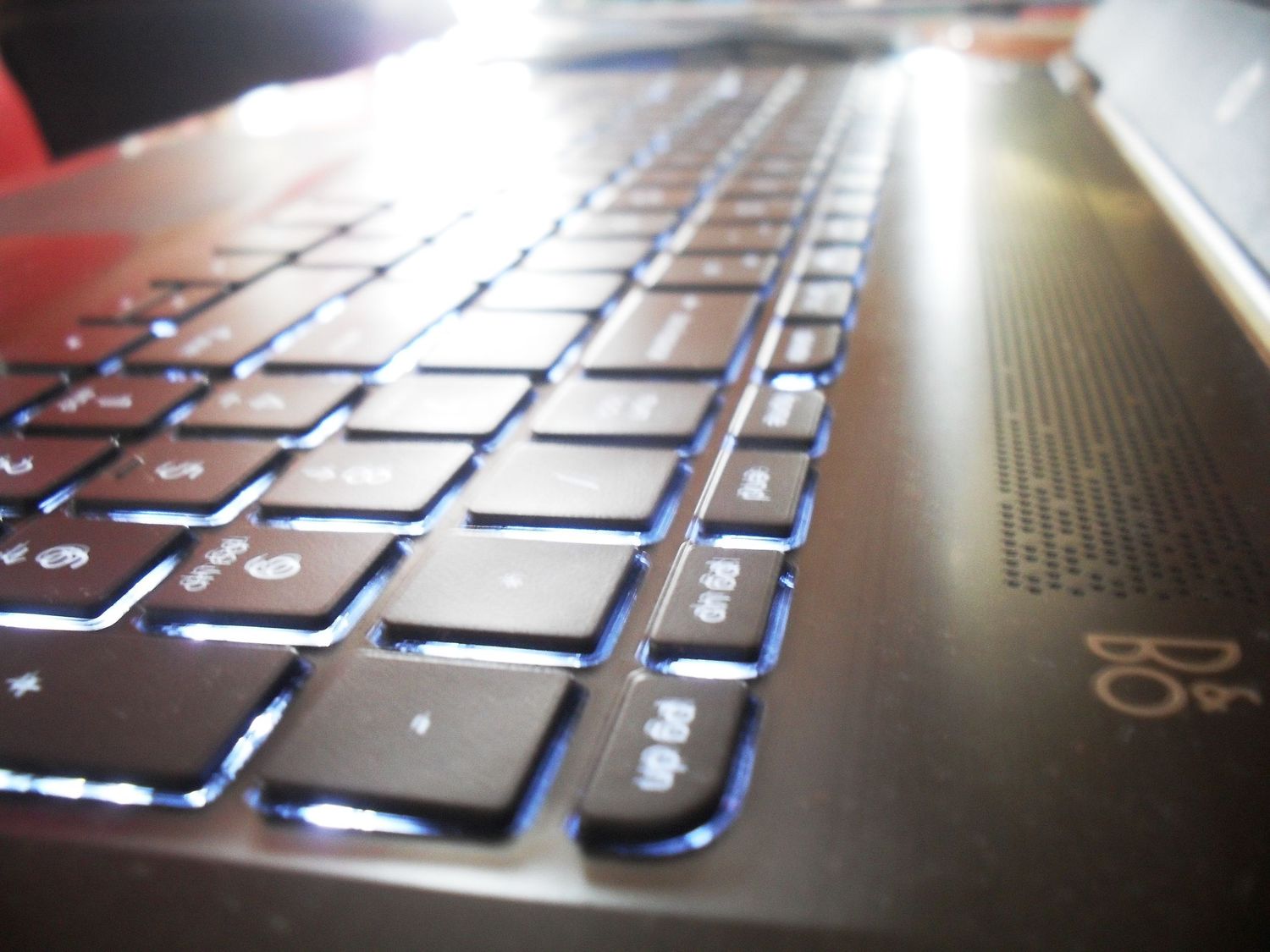 Close-up macro shots of a backlit laptop keyboard showing illuminated keys from different angles.