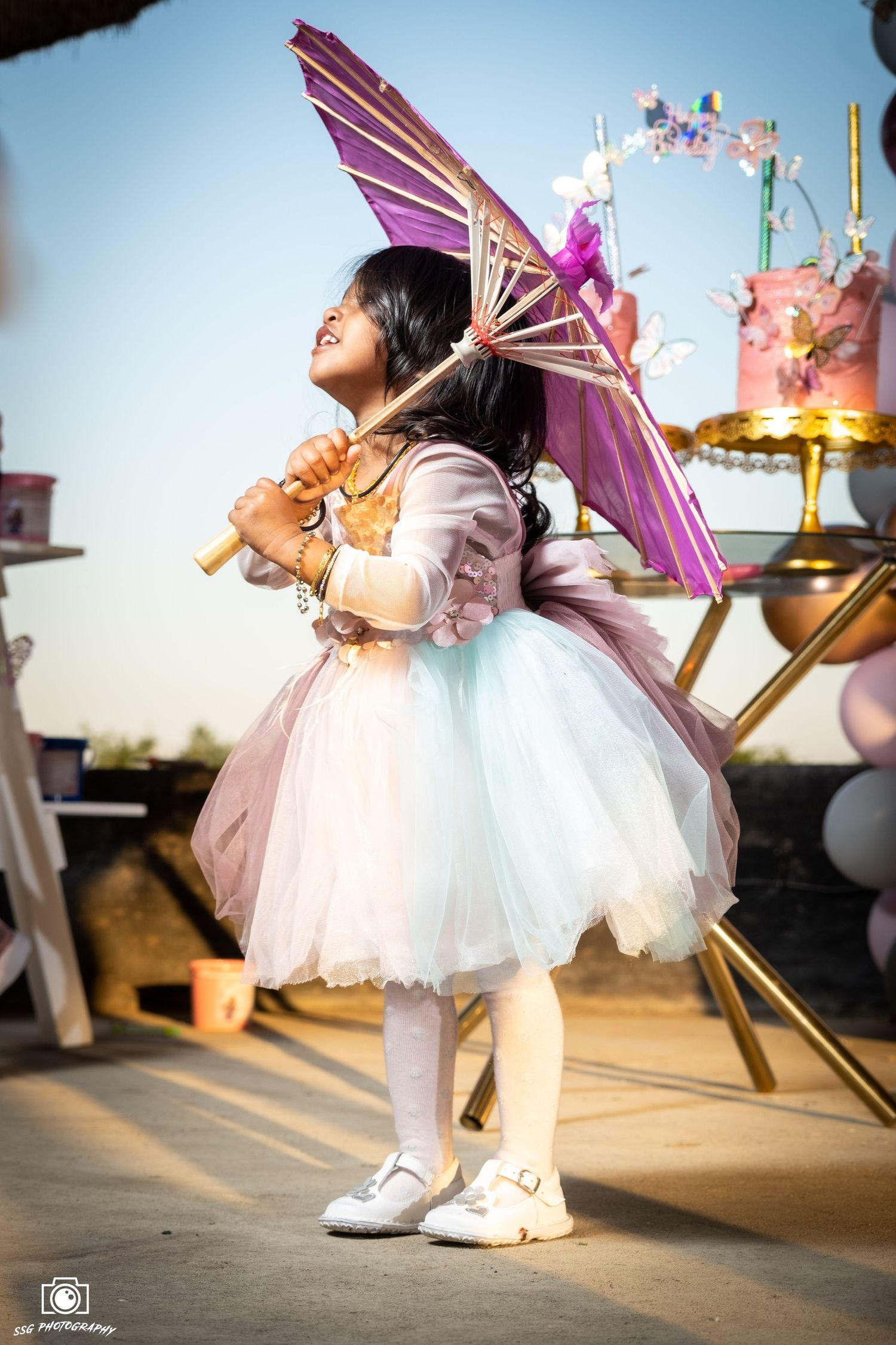 Capturing candid moments at a Gauteng wedding: A child in a pink and white dress with a lit-up umbrella, photographed by SSG Photography.