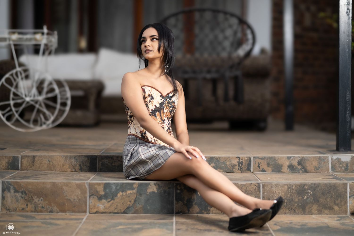 Artistic portrait composition on wooden steps with rustic architectural elements.