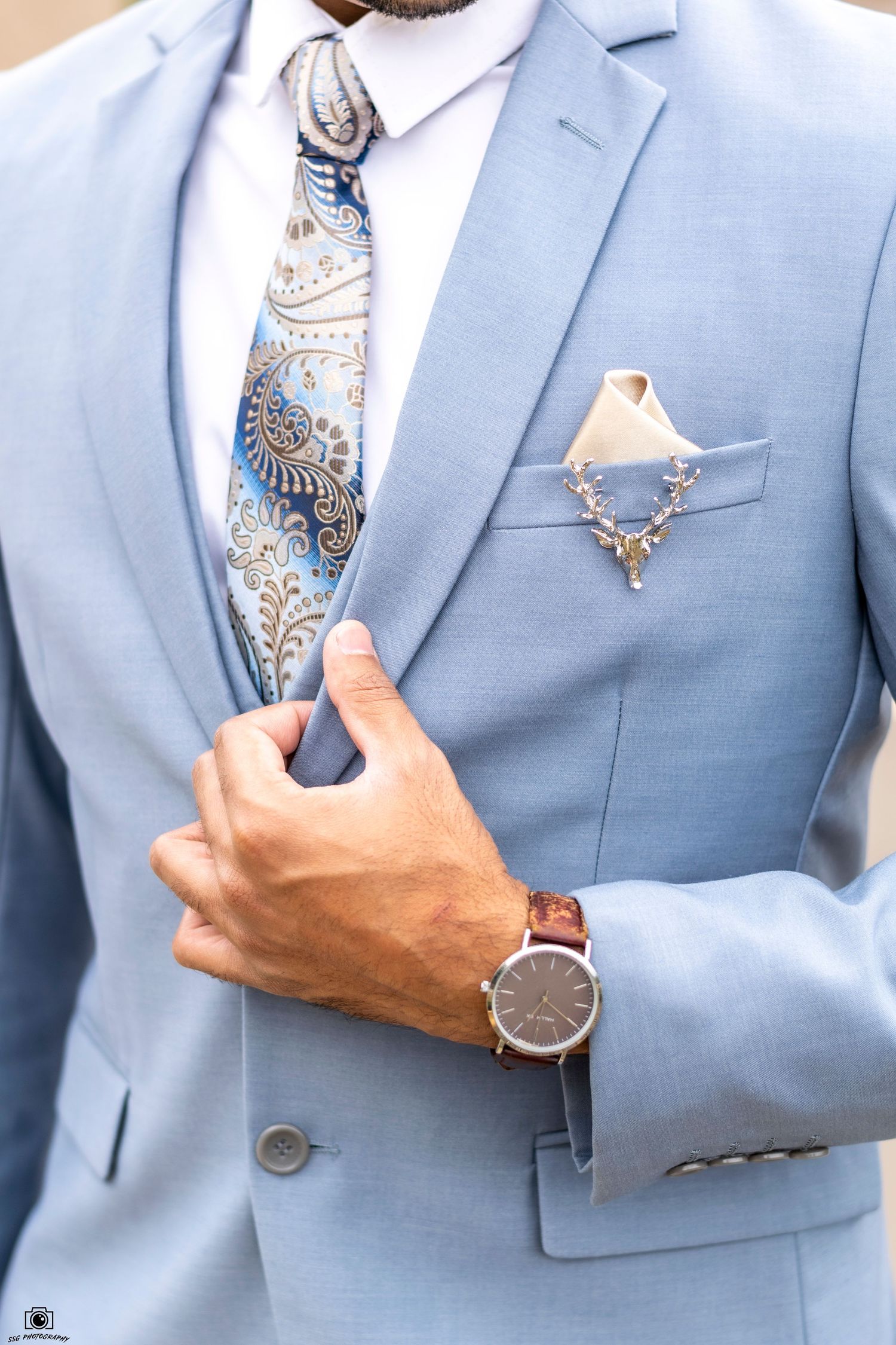 Detail shots of light blue suit with patterned tie and wristwatch accessories.