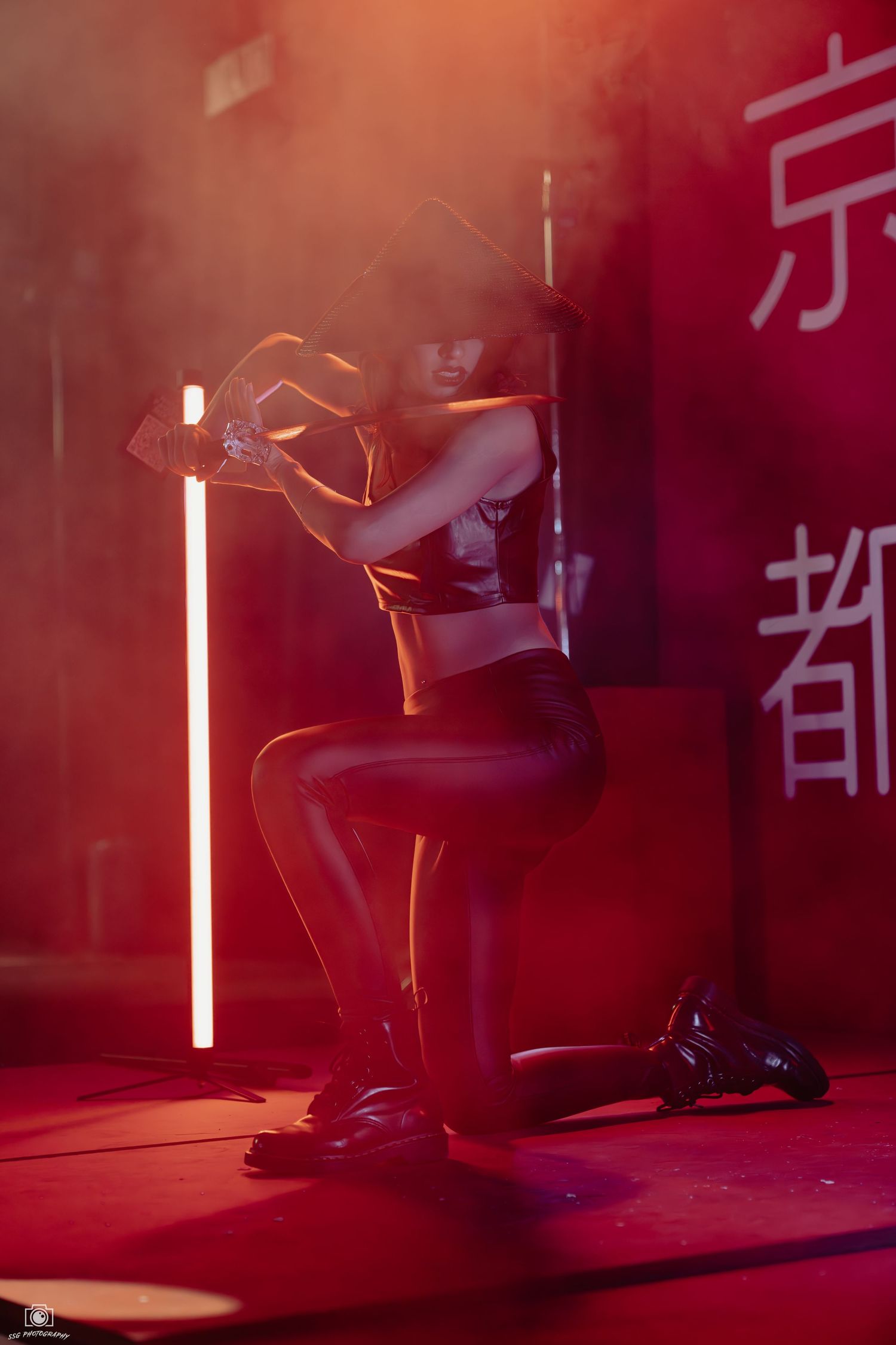 Artistic portrait with red lighting and smoke effects against wall with Asian typography.