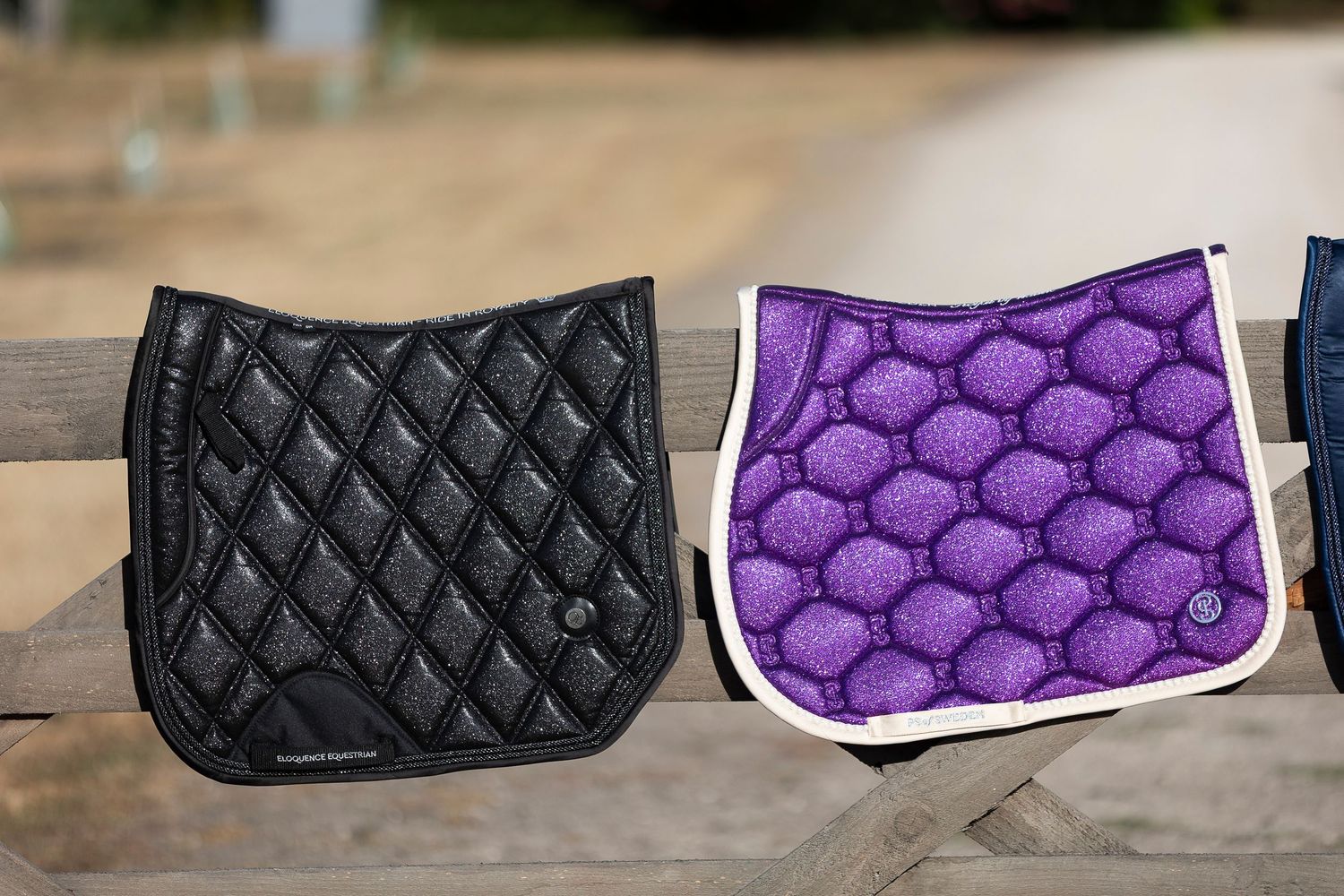 Collection of quilted saddle pads in black, purple, and white arranged in a row.