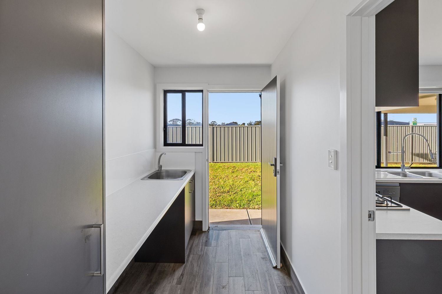 Spacious kitchen and living area with dark cabinetry, large windows, and contemporary finishes.