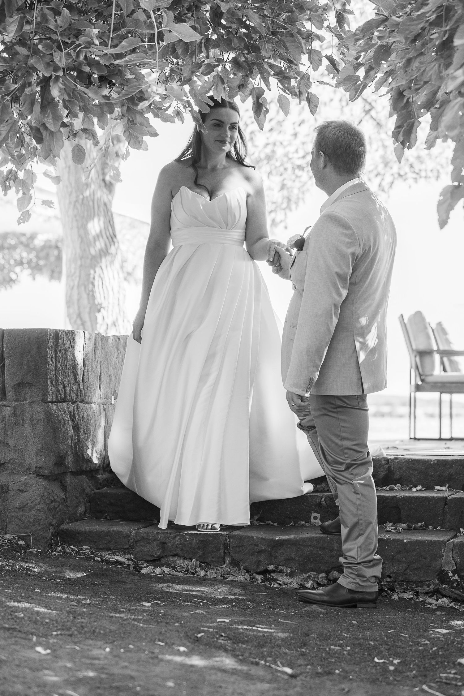 Black and white wedding portraits under tree canopy showing intimate moments.