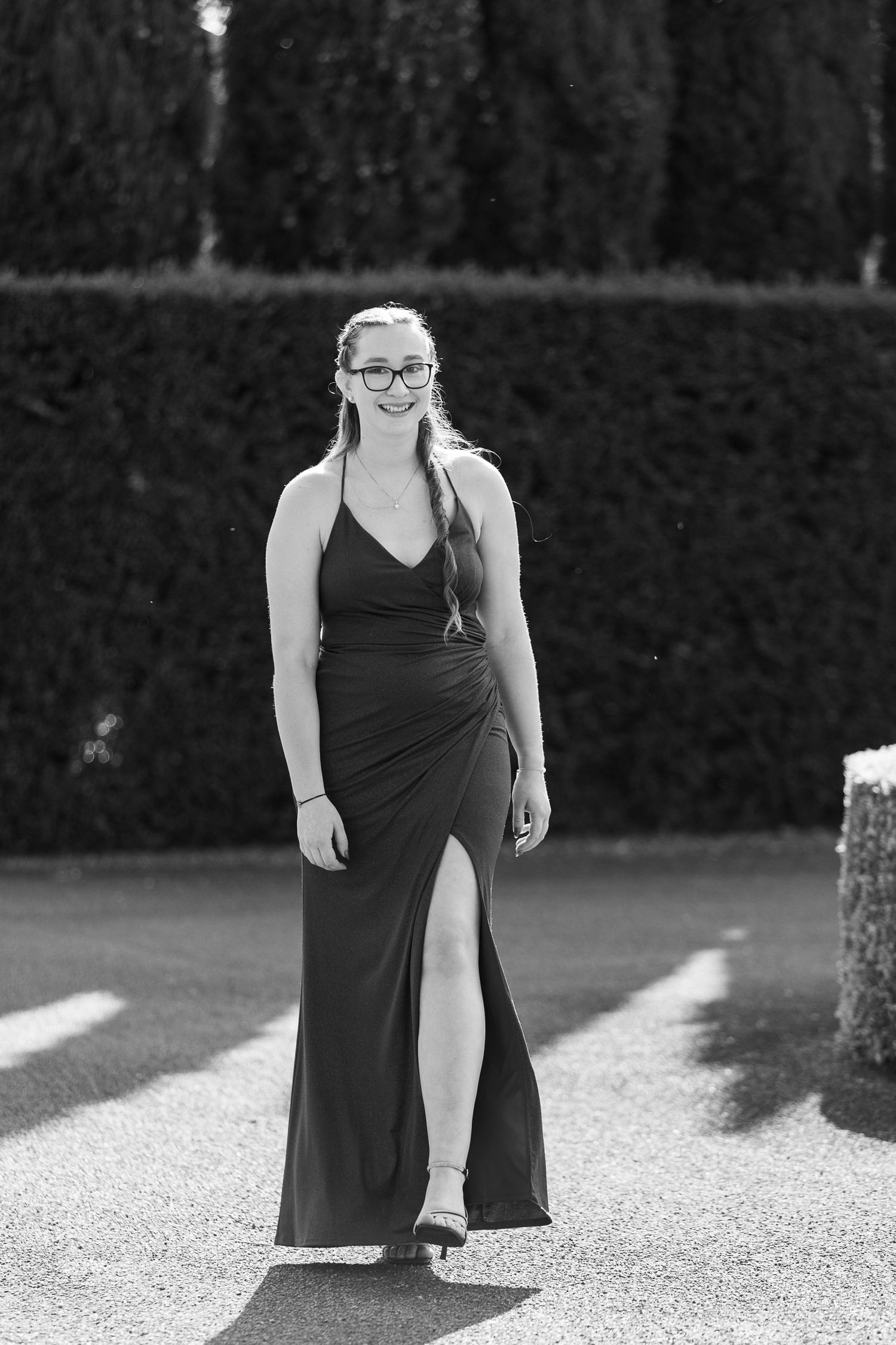Black and white portrait of formal wear against garden backdrop.