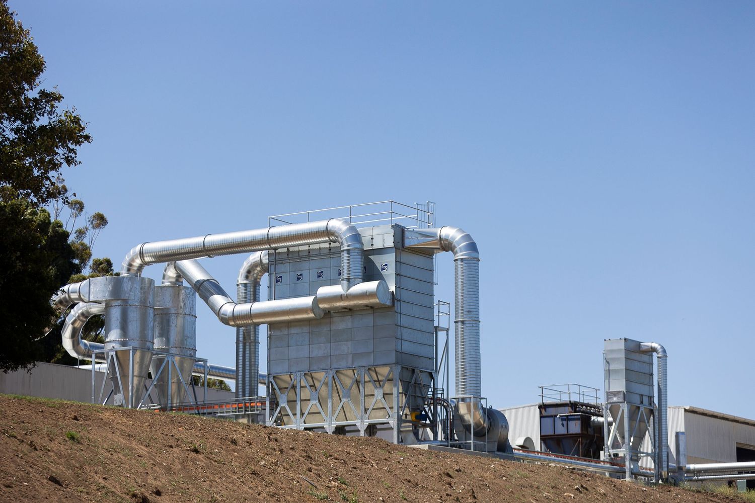 Industrial gas processing equipment and piping systems arranged in a panoramic view against a blue sky background.