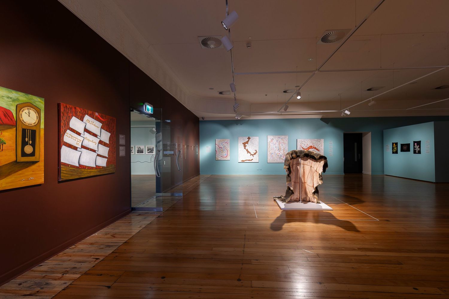 Modern museum gallery space with artwork displayed along minimalist walls.