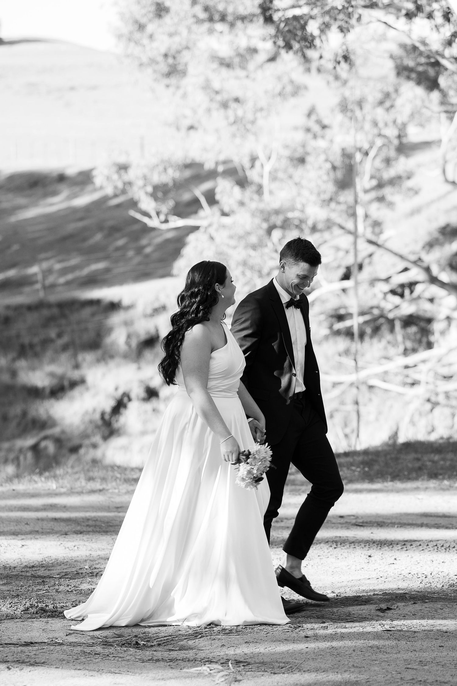 Black and white wedding photo sequence showing couple walking together on a scenic outdoor path.
