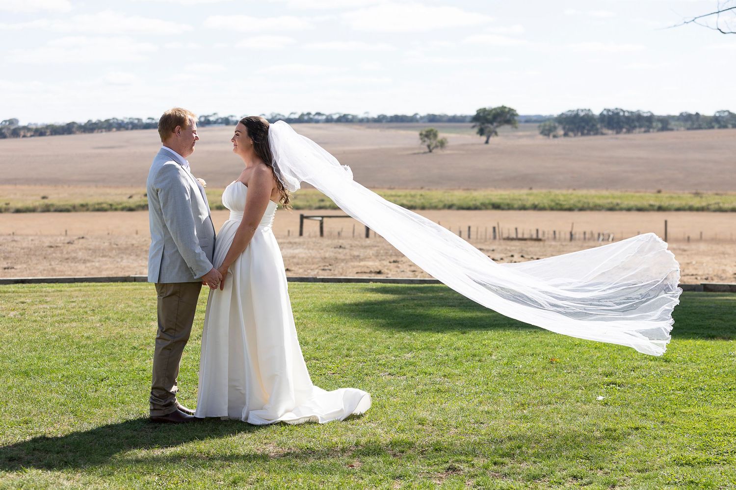 Wedding sequence showing bride's flowing veil caught in wind across open field.